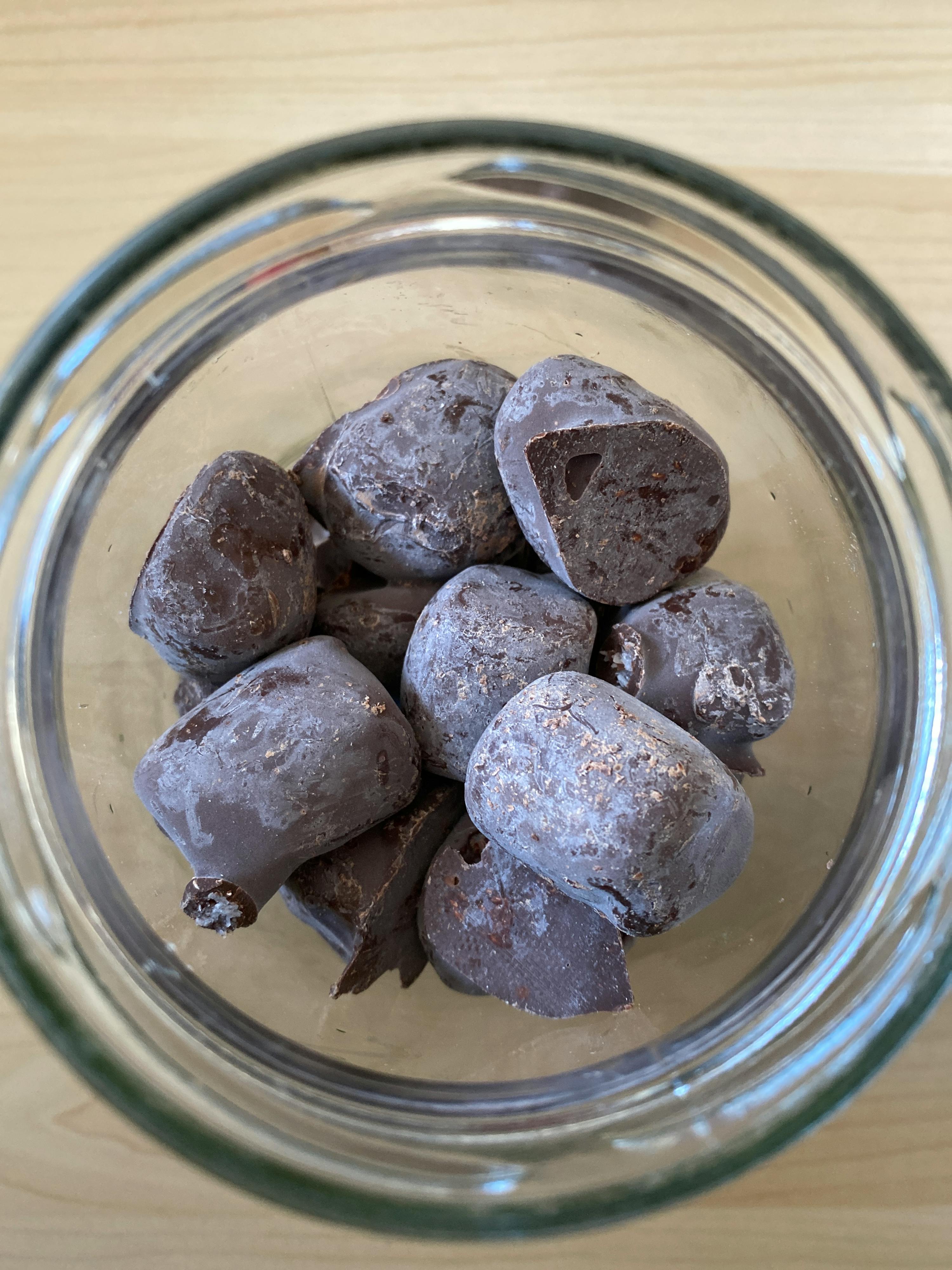 a glass bowl filled with pieces of chocolate on a table