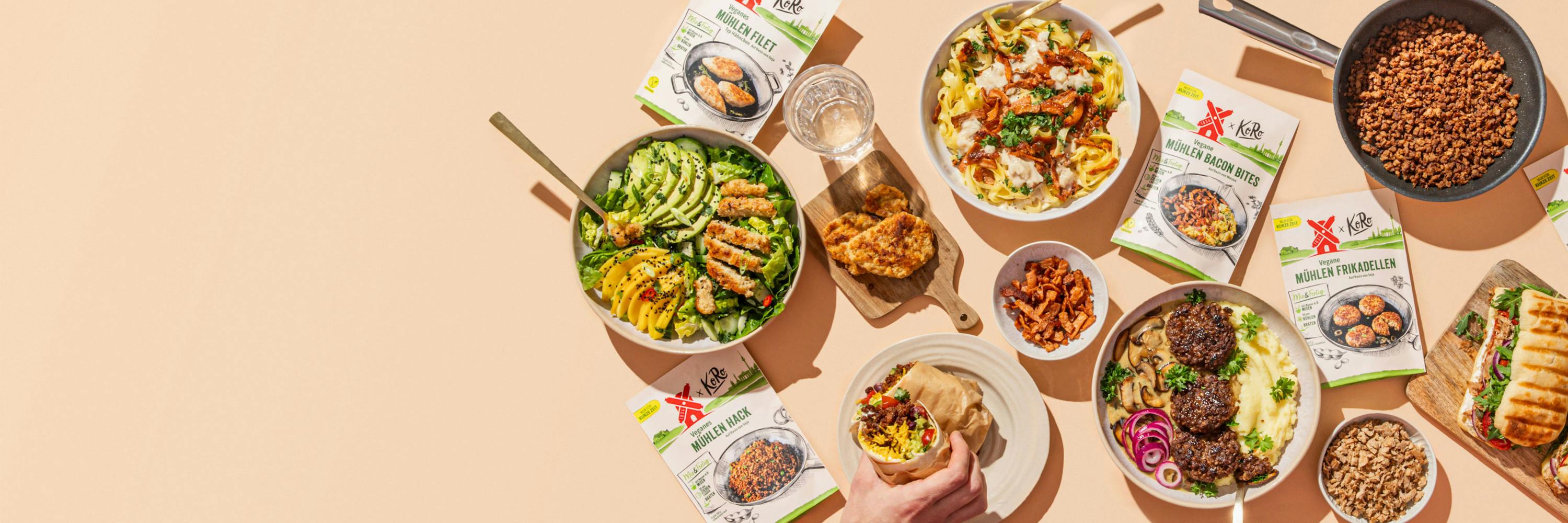 Eine Person nimmt einen Sandwich aus einer Schüssel mit einer Mahlzeit aus einem Kochbuch