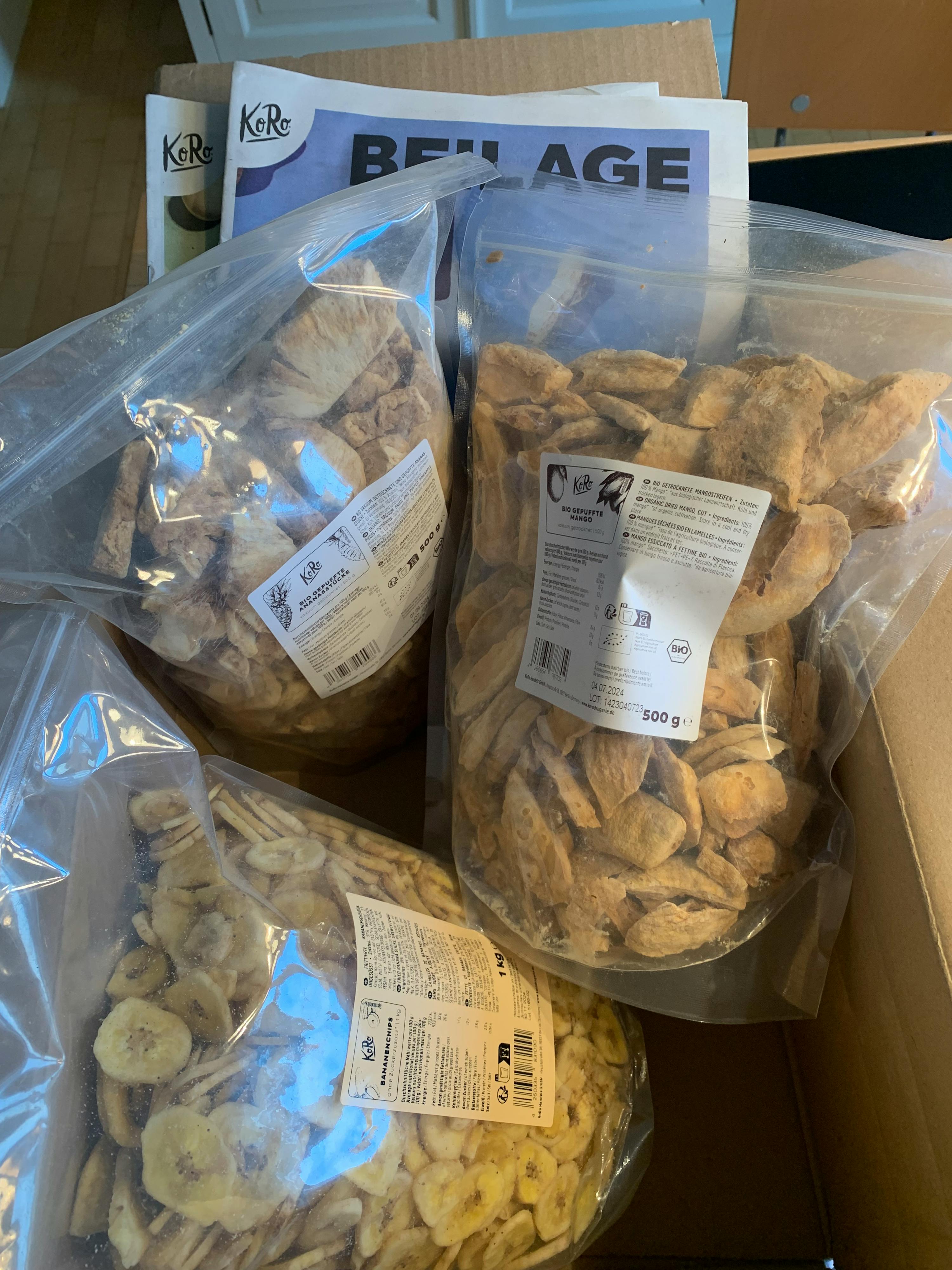 a bag of dried bananas sits next to a bag of dried apples