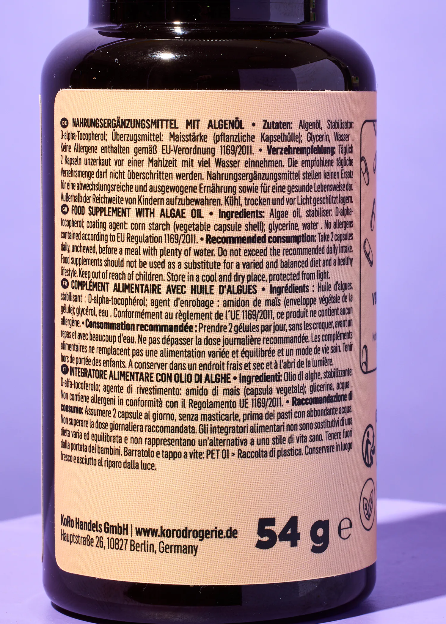 die Rückseite einer schwarzen Flasche mit 54 g steht auf einem lila Hintergrund