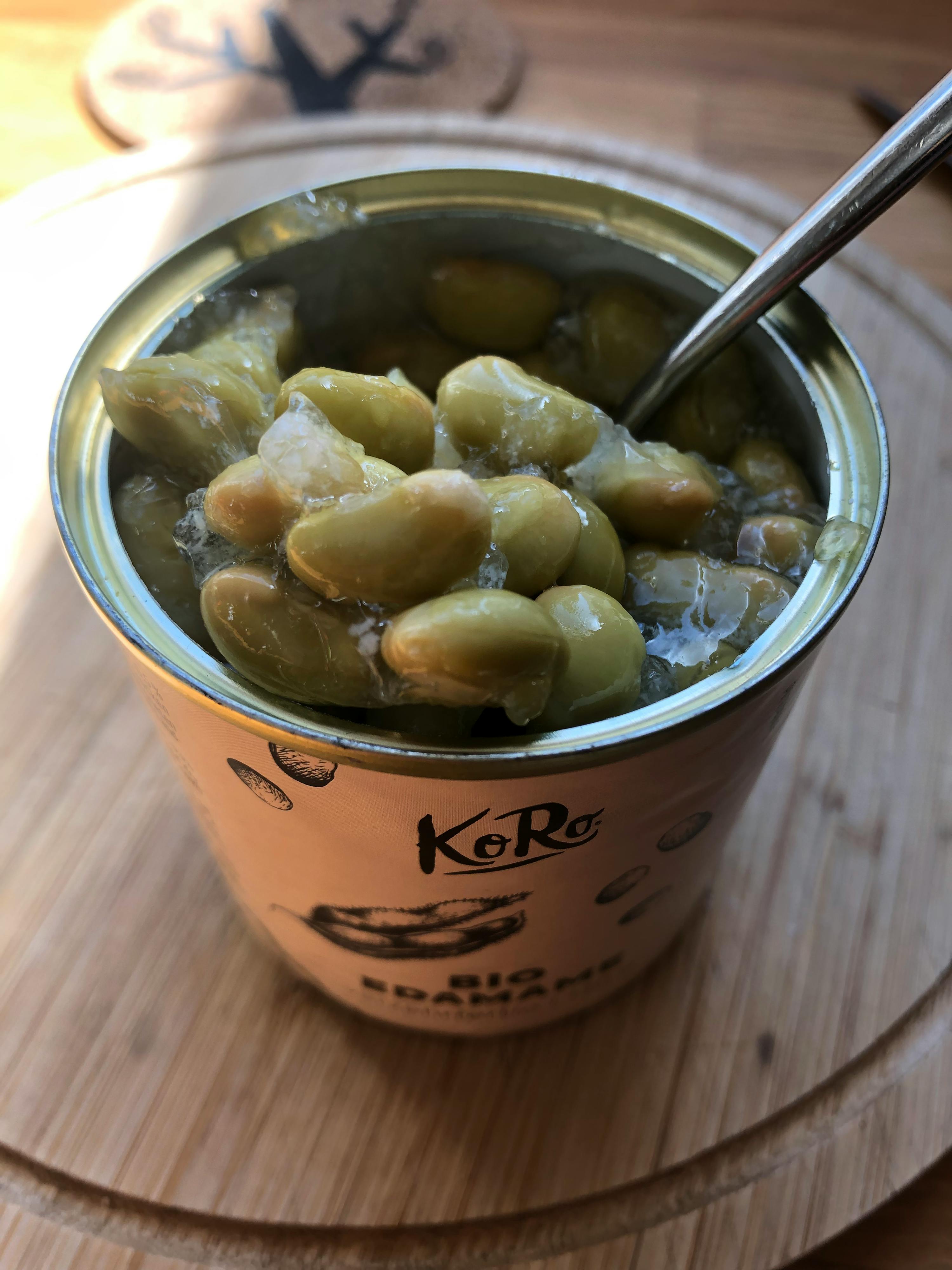 eine Dose grüne Bohnen mit einem Löffel darin