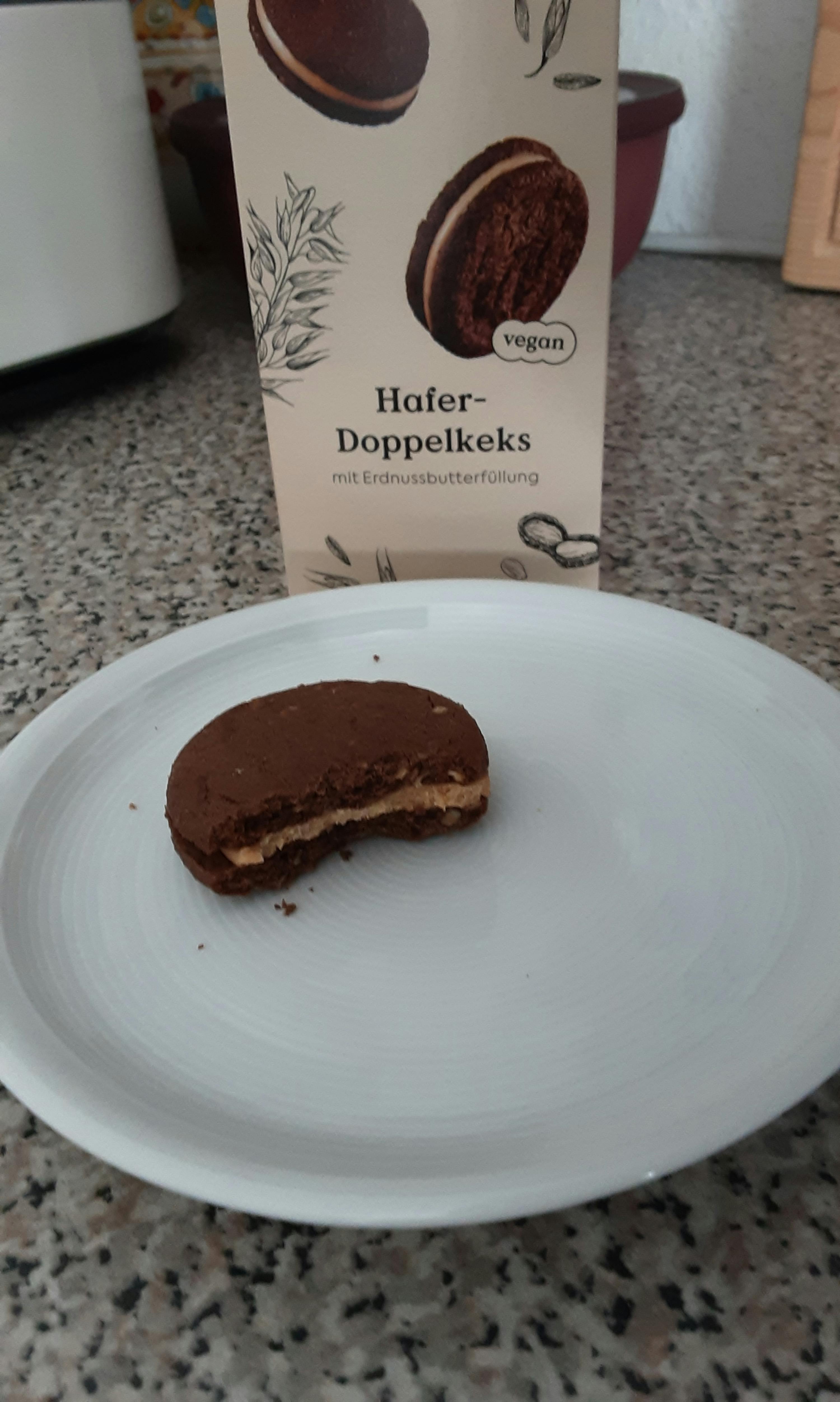 ein weißer Teller mit einem Stück doppelkeks darauf