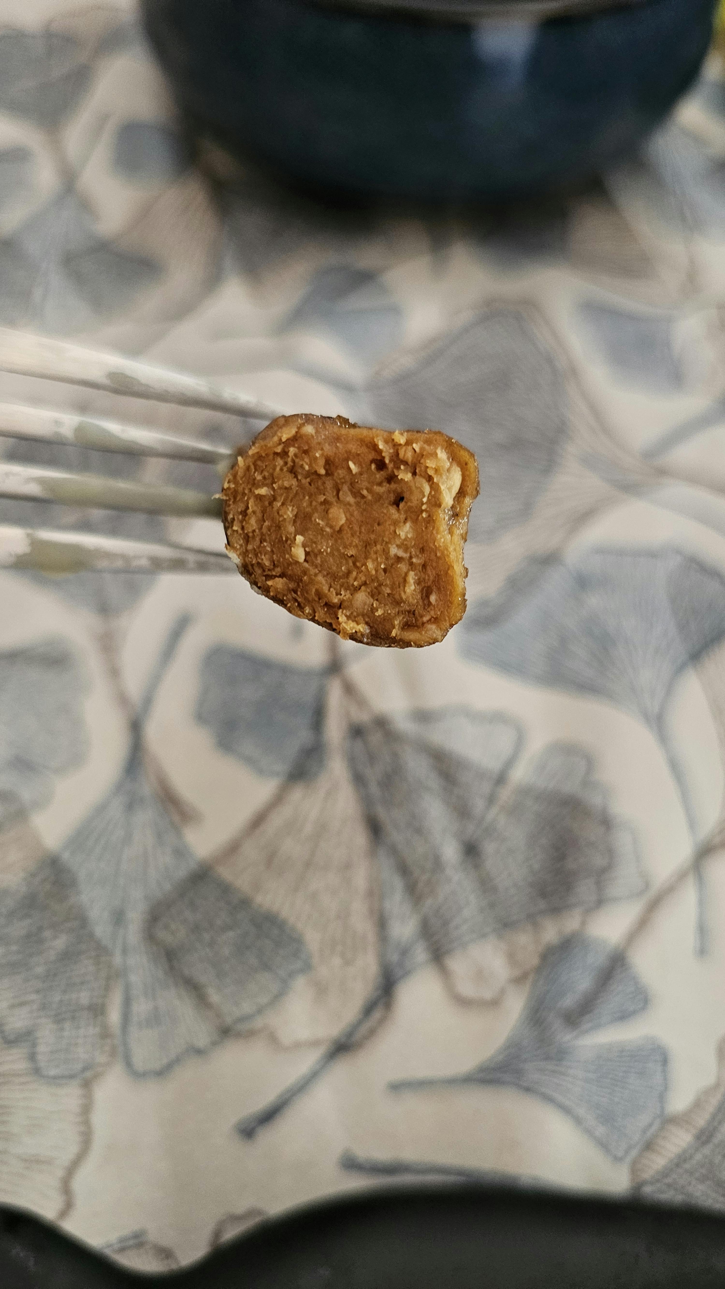 a piece of food on a fork with a floral background