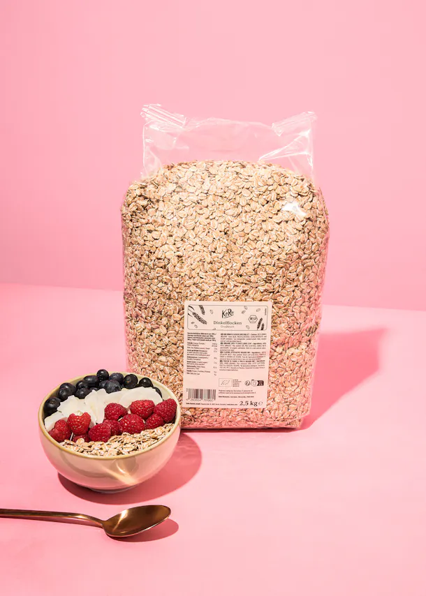 a bag of oats sits next to a bowl of berries