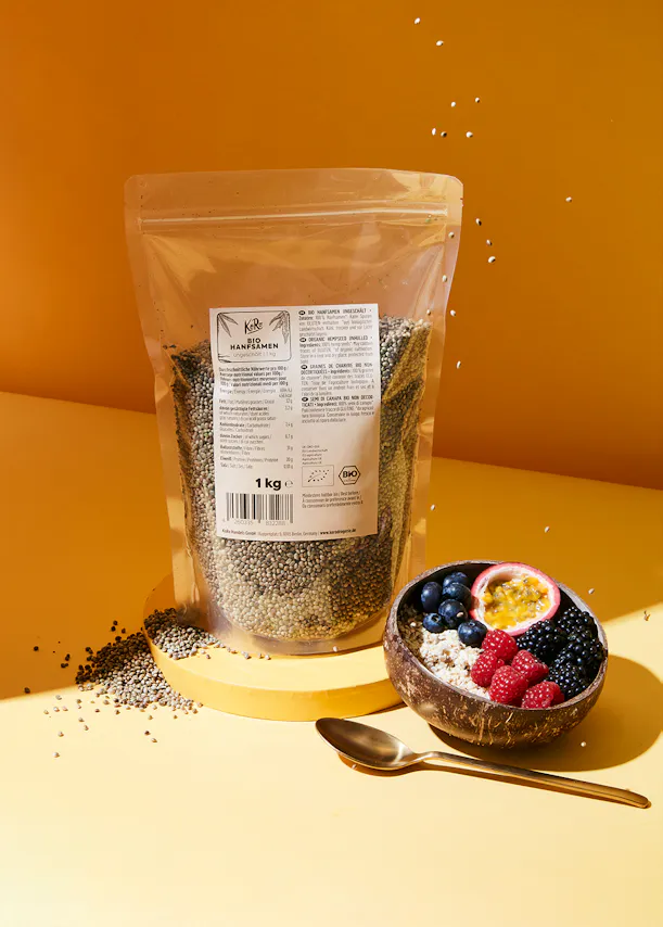 a bag of chia seeds sits next to a bowl of fruit