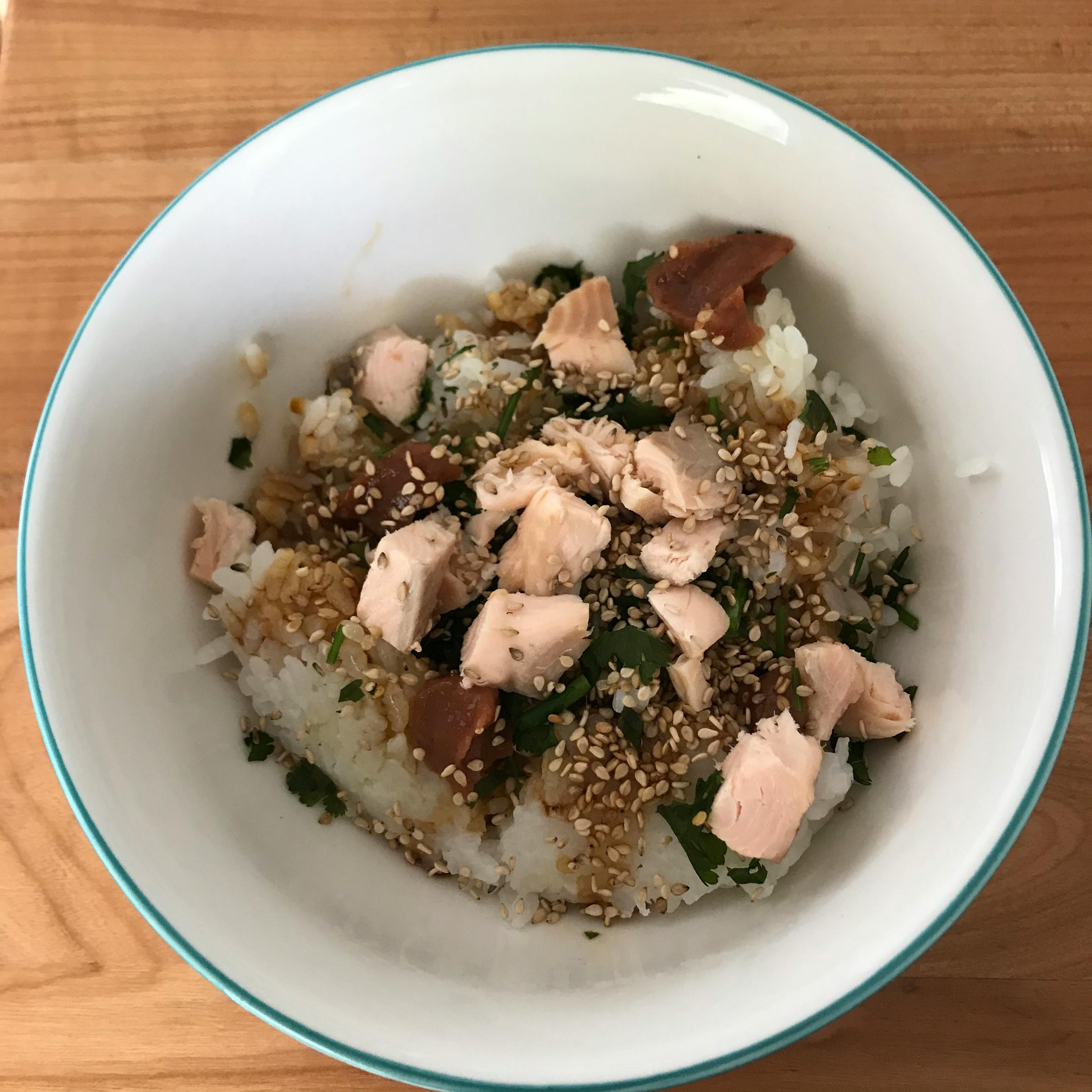 a bowl of rice with meat and sesame seeds on top