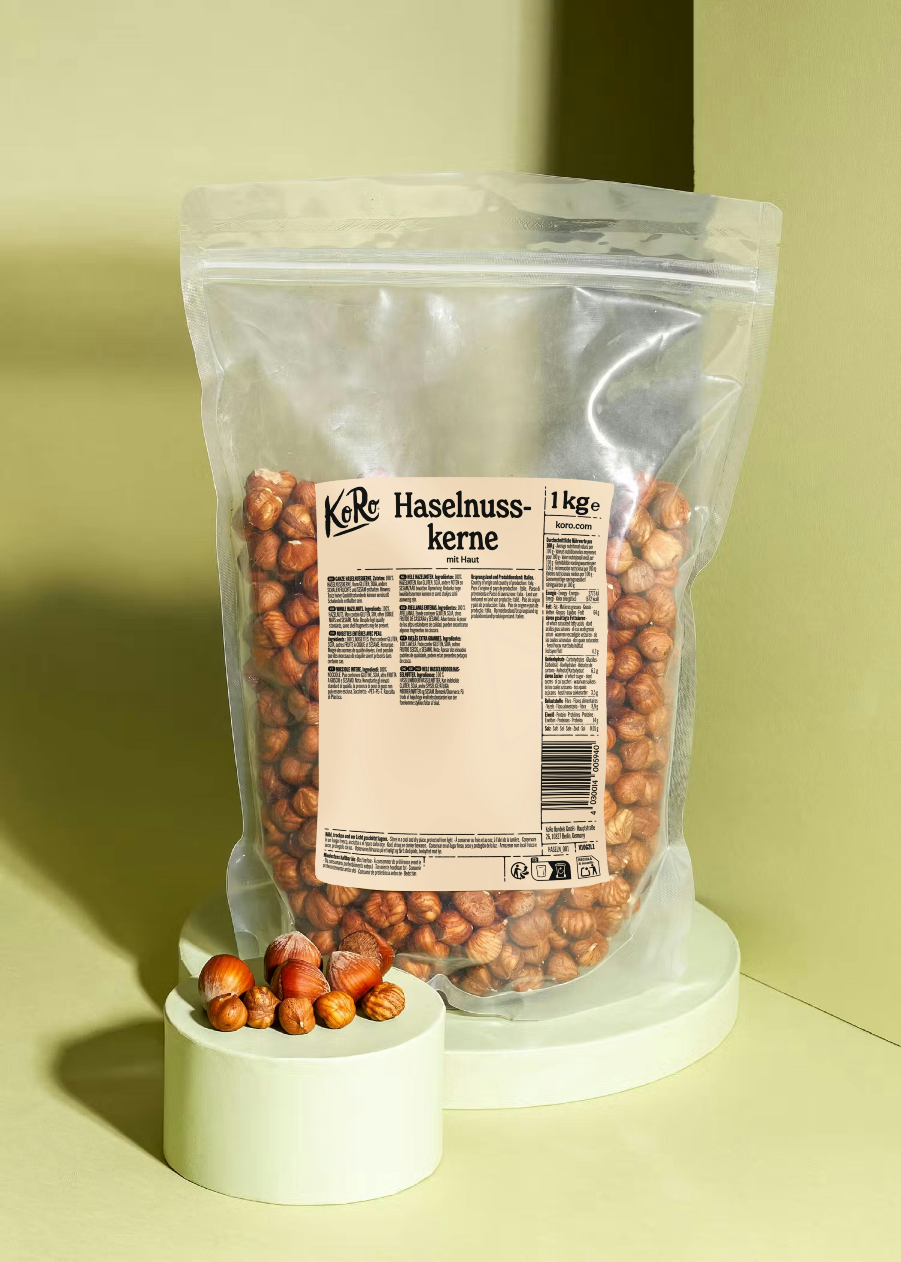 a clear plastic bag of koro 1kg hazelnut kernels sits on a light green stand, with a few whole and shelled hazelnuts on a smaller stand in the foreground.