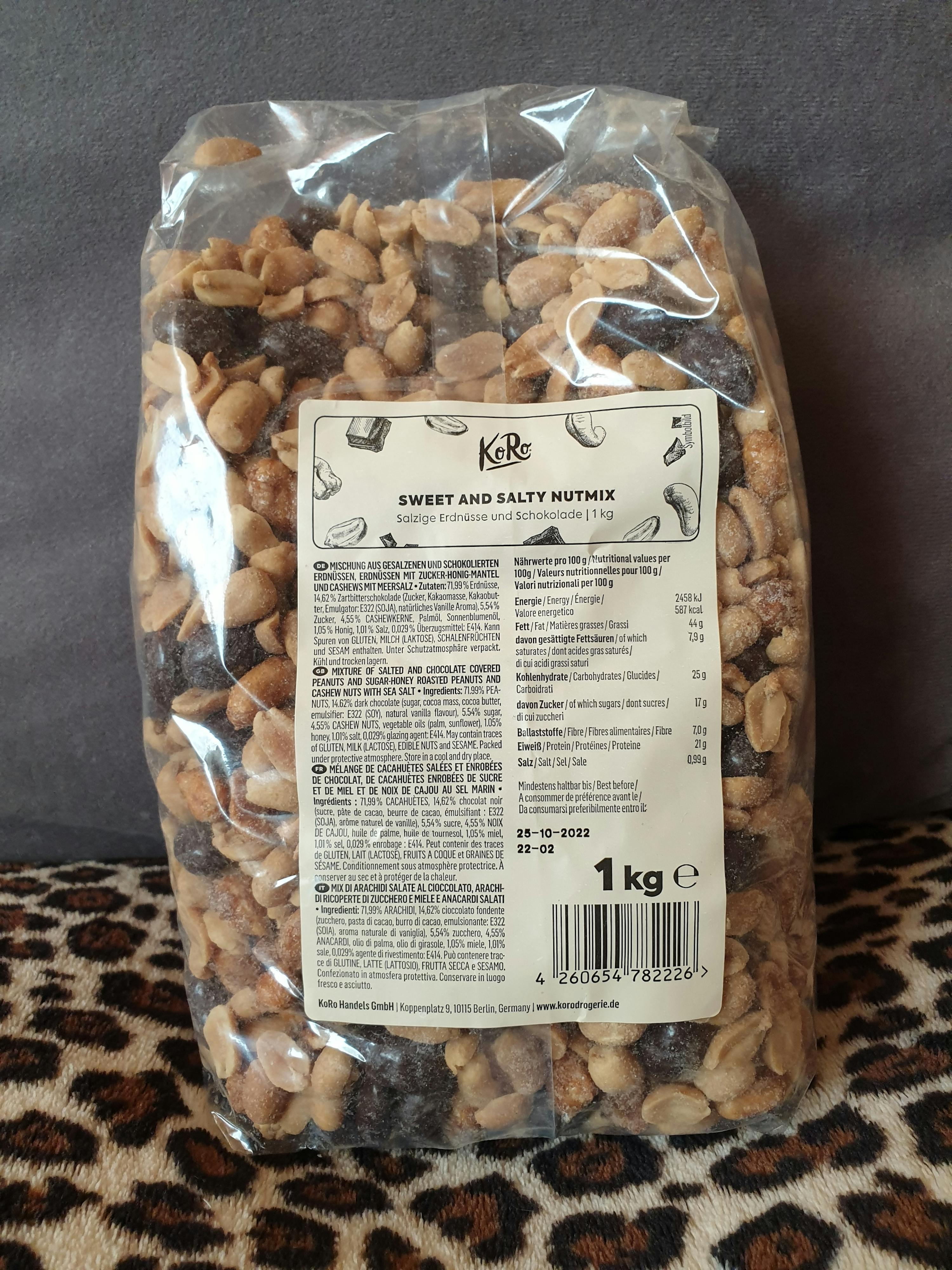 eine Packung mit Erdnüssen und Schokoladenstückchen steht auf einem leopardenmusterigen Bett