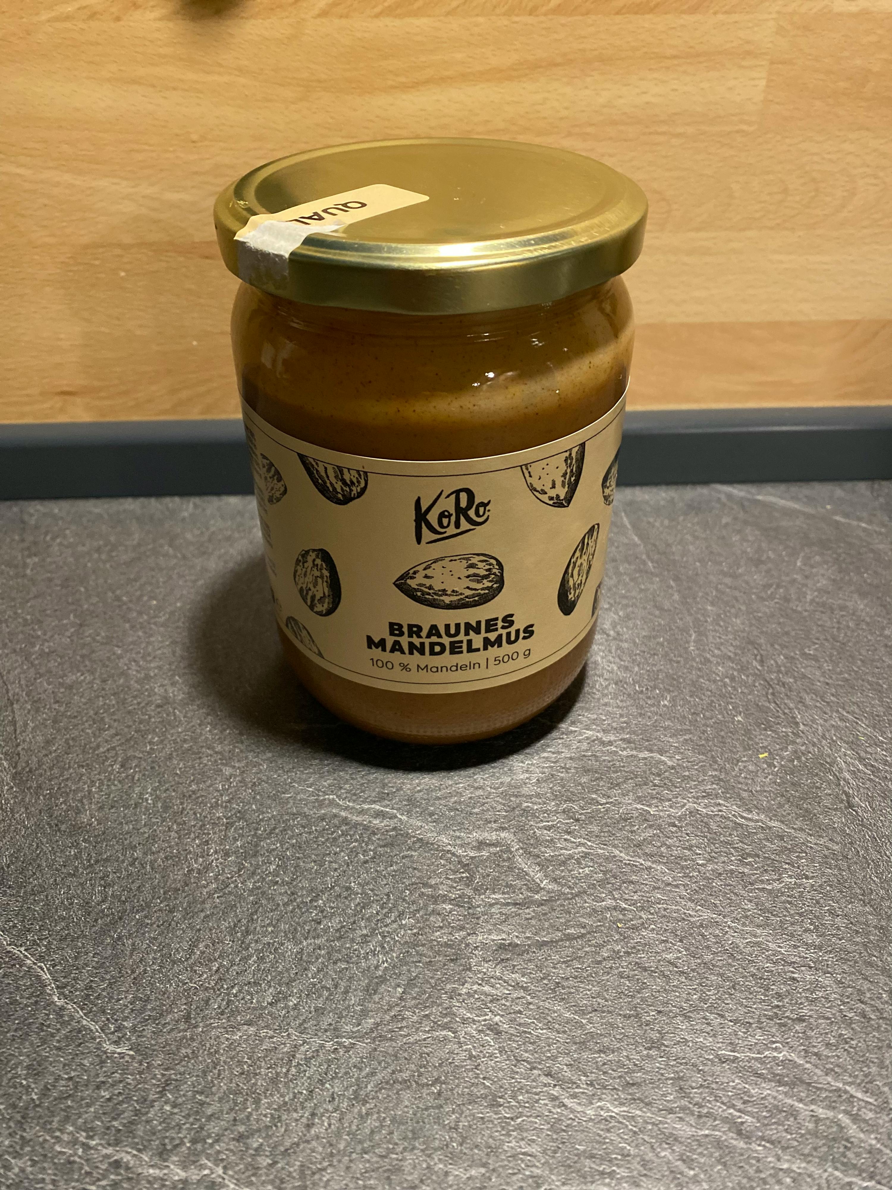 ein Glas braunes Mandelmus liegt auf einem Tisch