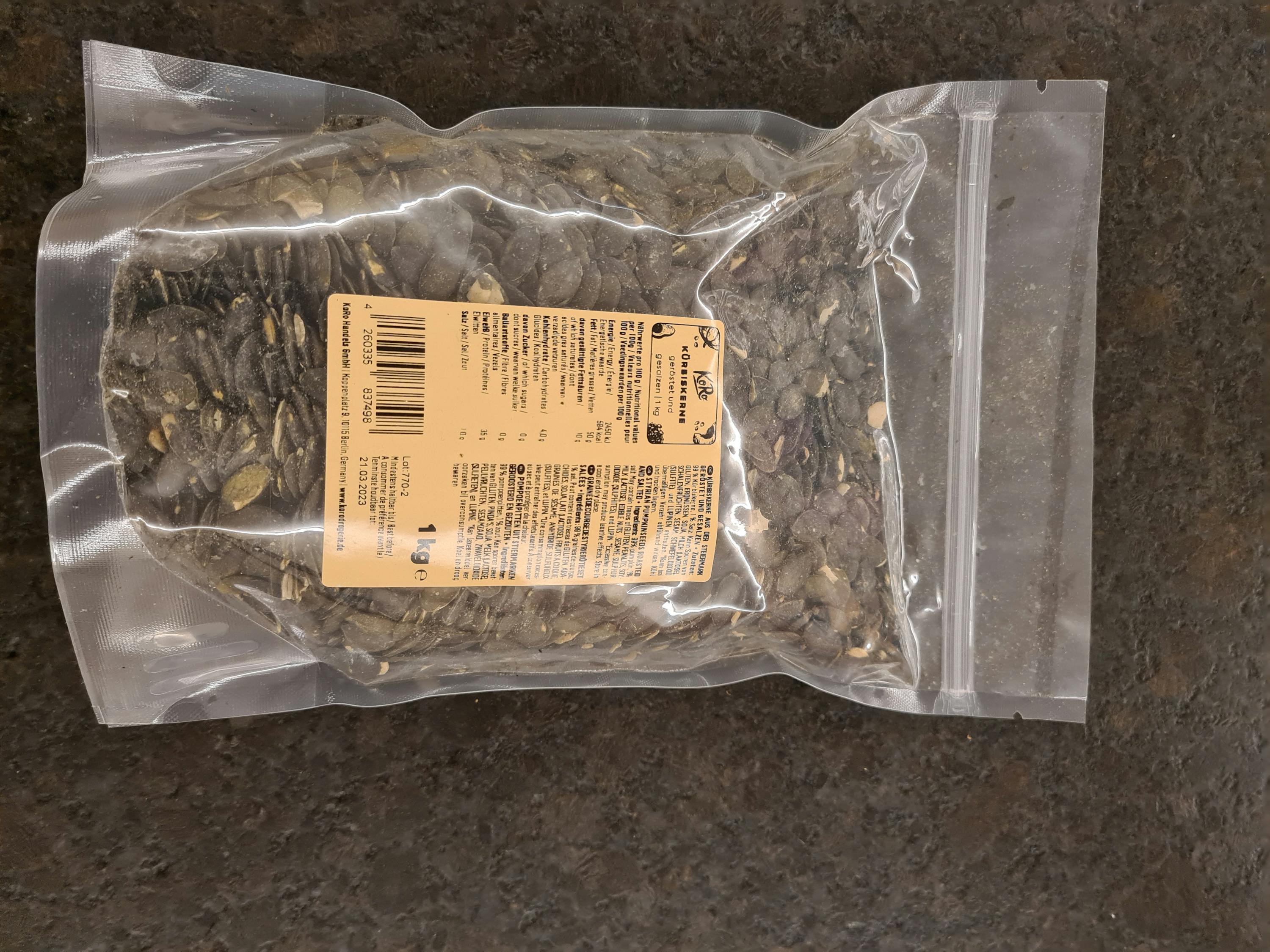 un sacchetto di semi di zucca con una etichetta che dice " 1kg "