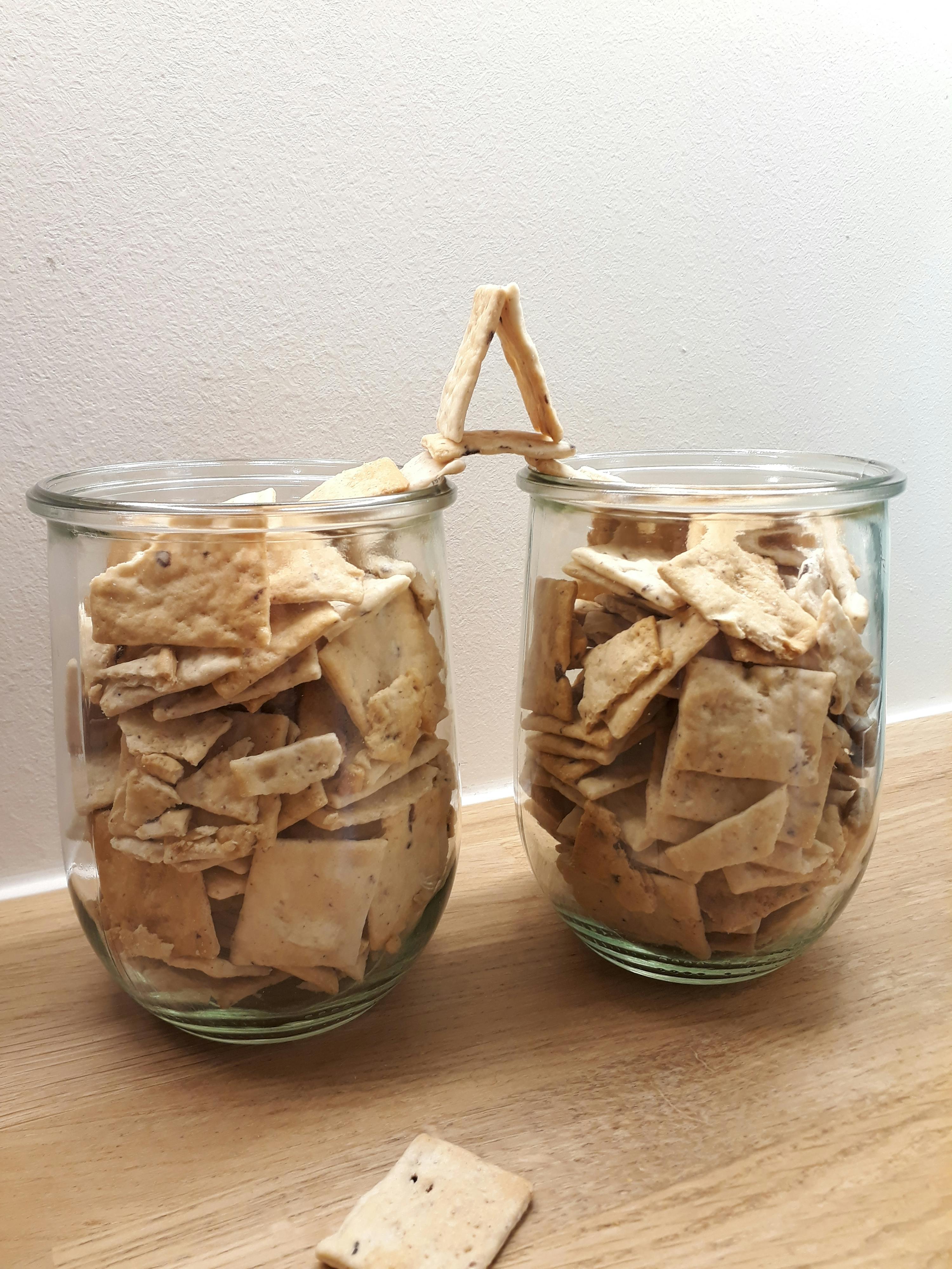 due vasetti di cracker sono su un tavolo di legno