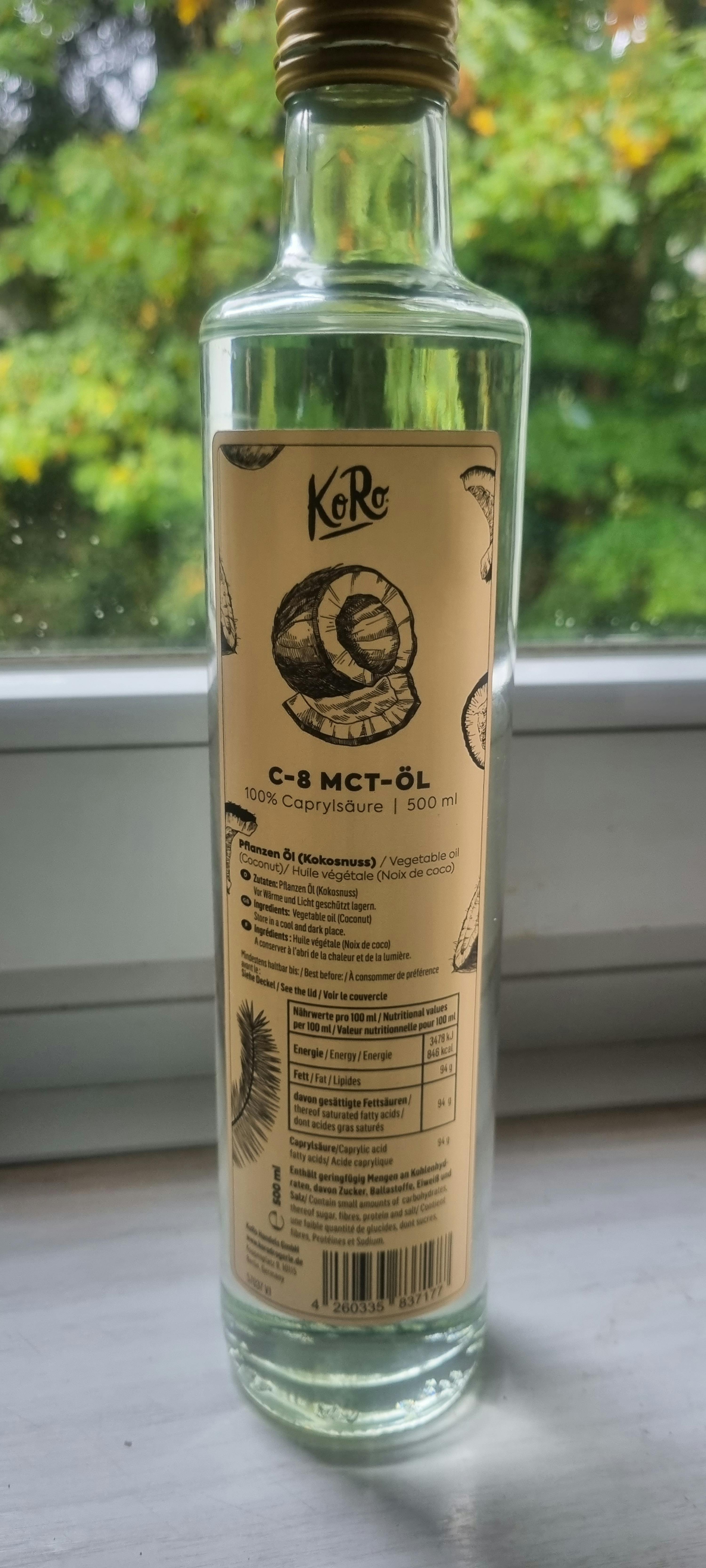 una bottiglia di olio mct è seduta su un tavolo davanti a una finestra