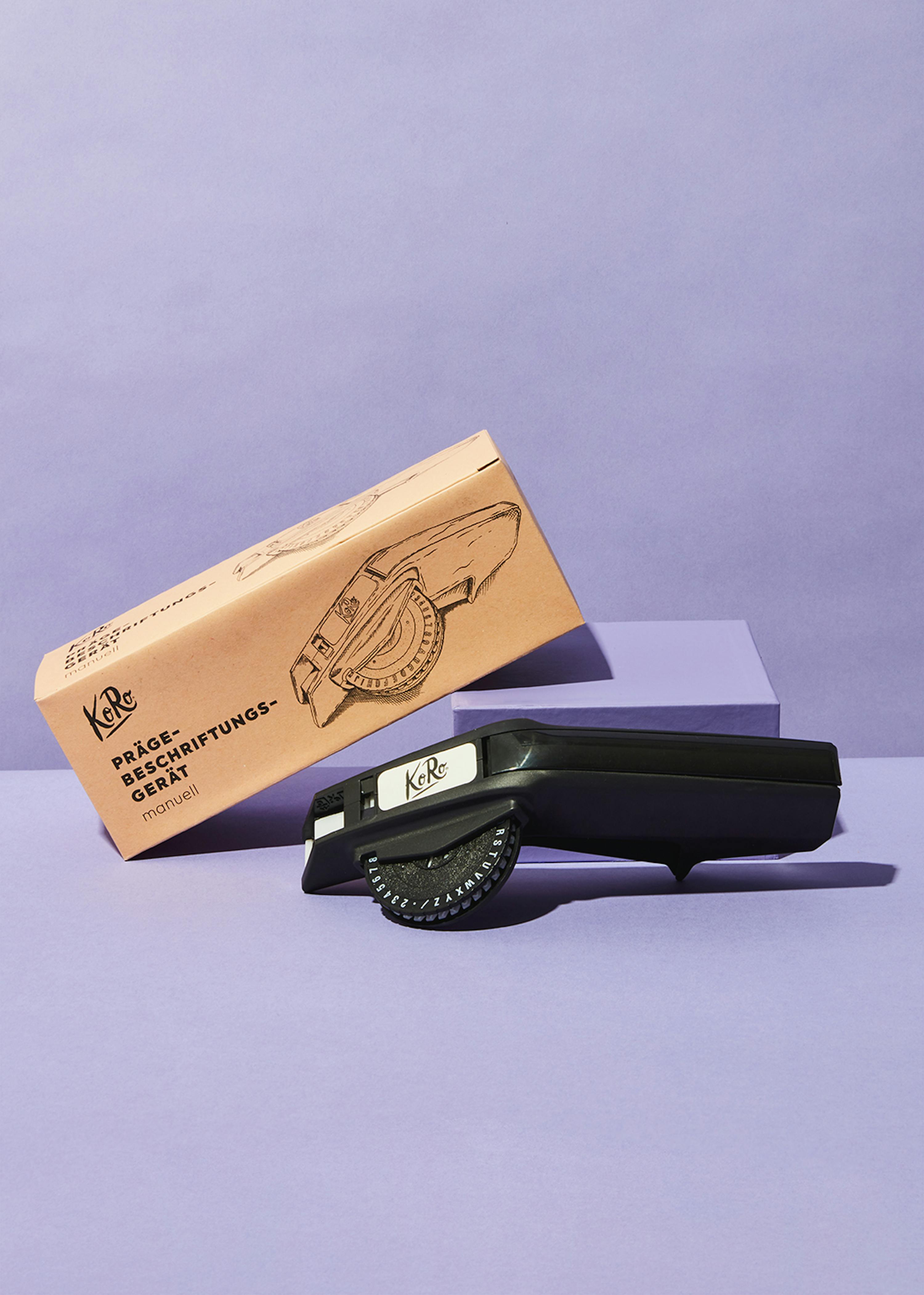 Etiqueteuse manuelle une machine à étiqueter est posée à côté d' une boîte de kraft