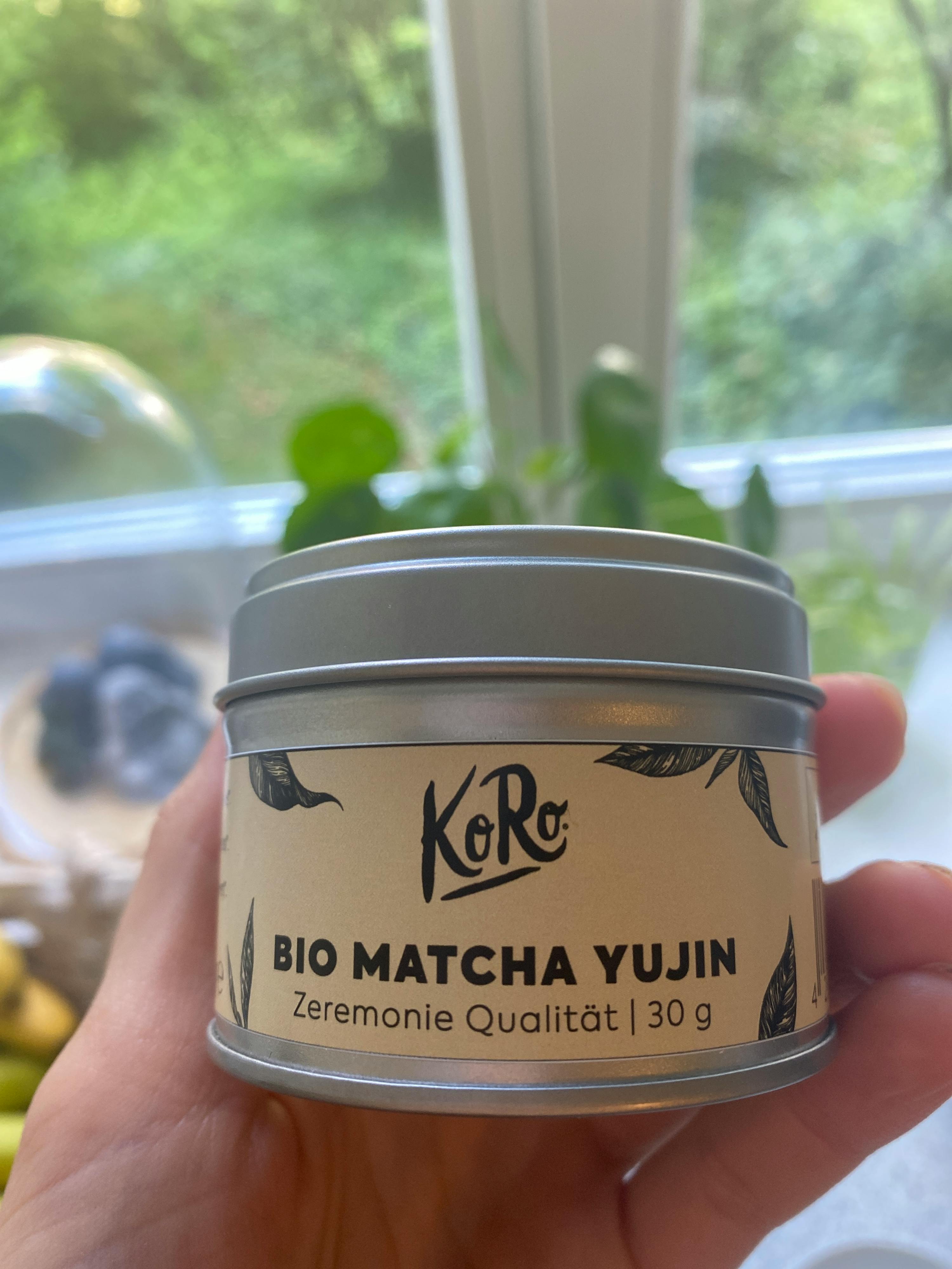 a person holding a can of bio matcha yujin