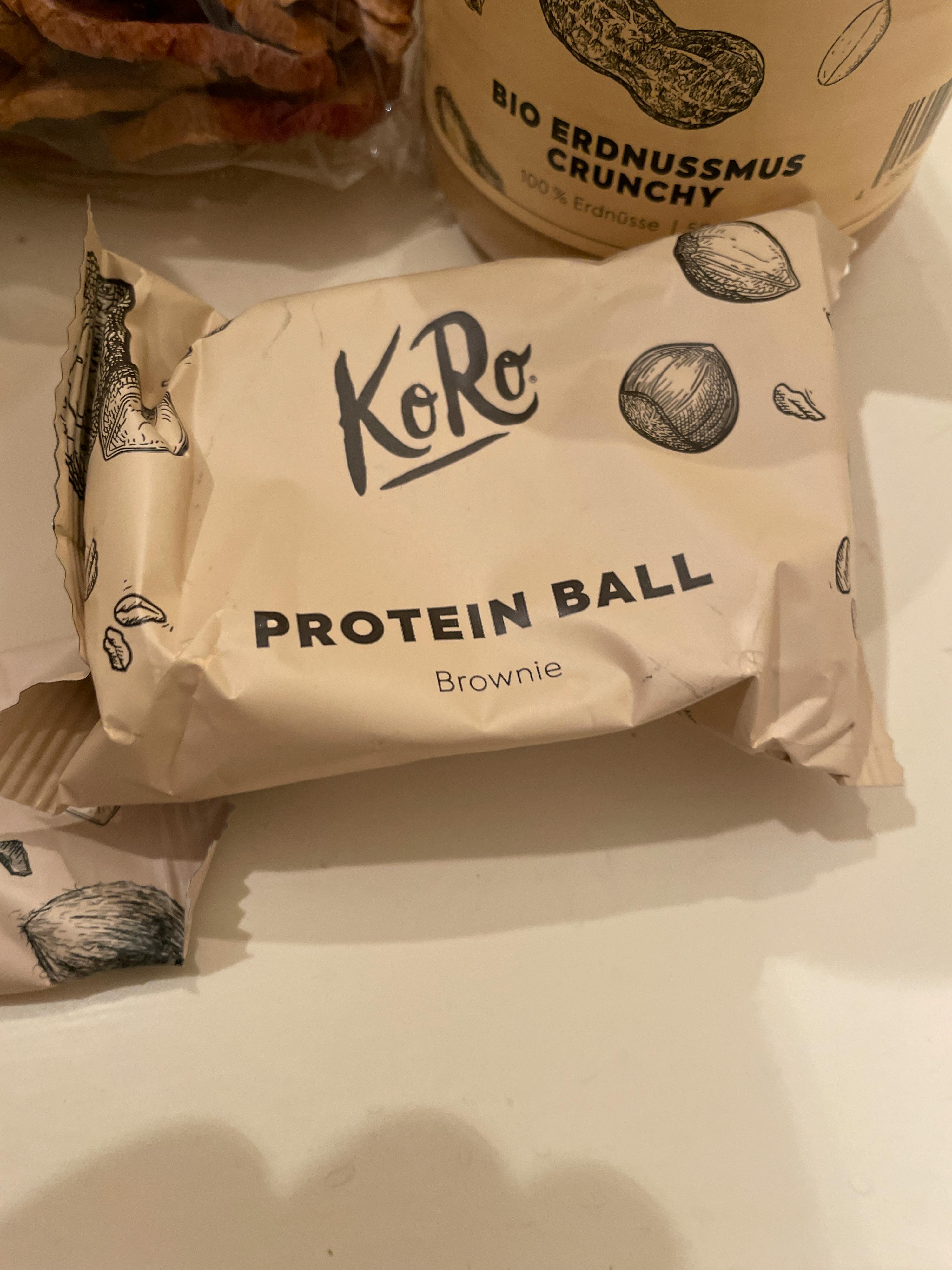 eine verpackte proteinkugel mit brownie-geschmack liegt auf einem tisch
