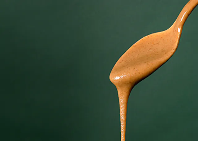 eine Nahaufnahme eines Löffels mit brauner Soße darauf