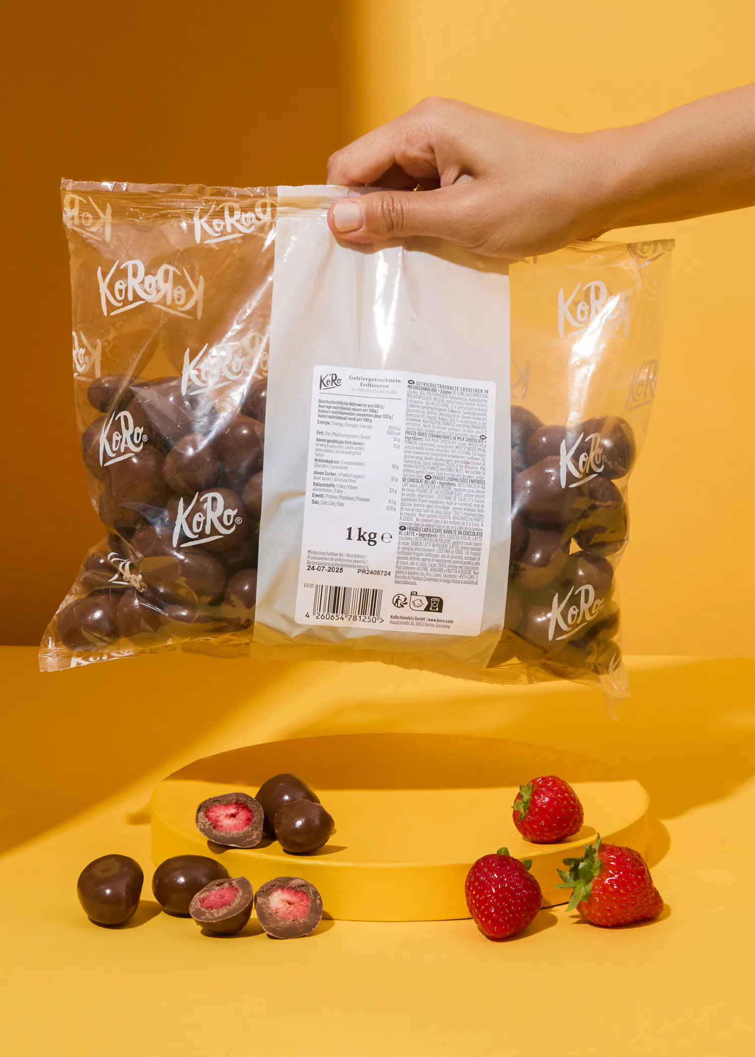 une personne tient un sac de chocolat enveloppé de fraises