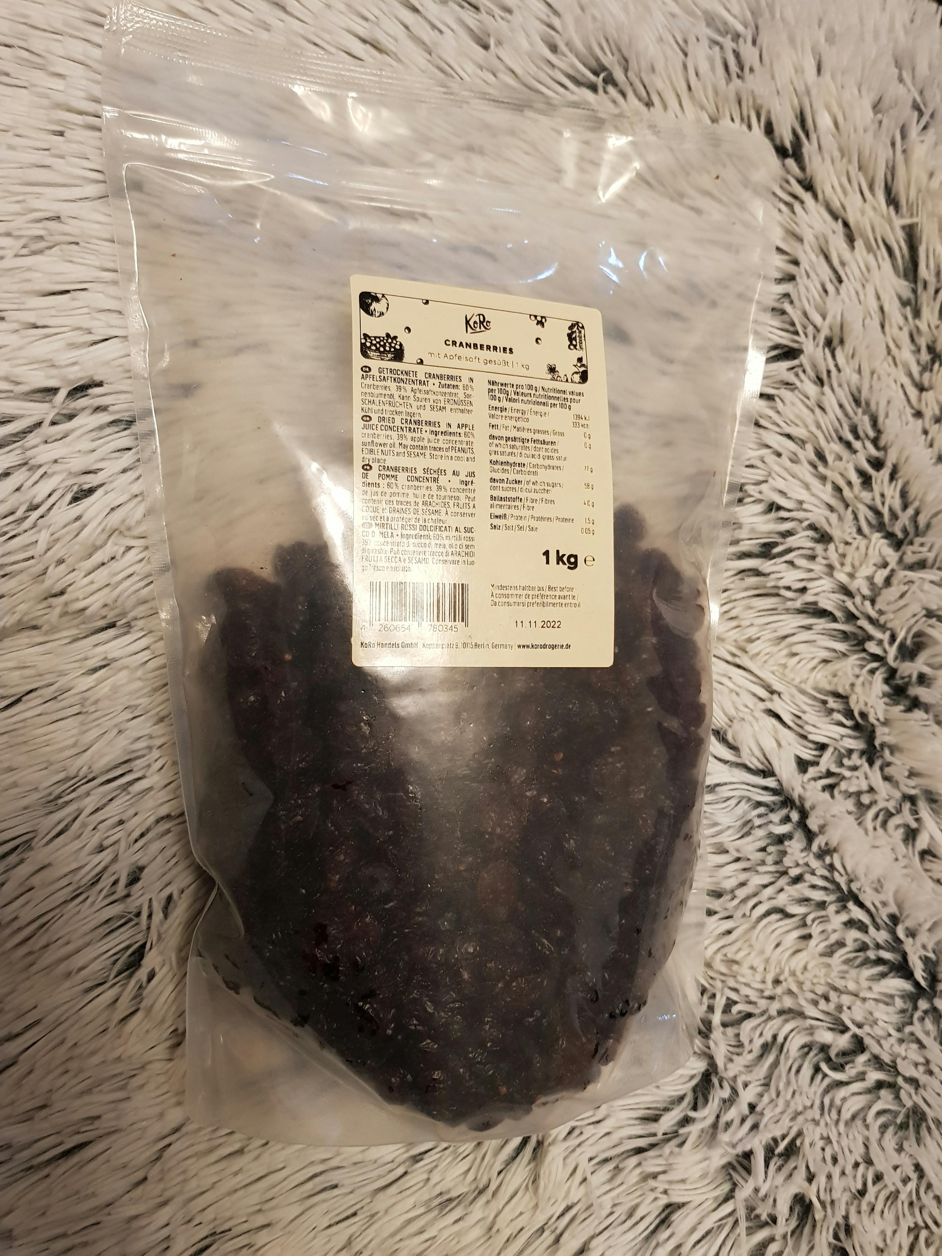 Eine Plastiktüte mit getrockneten Preiselbeeren steht auf einer flauschigen Decke