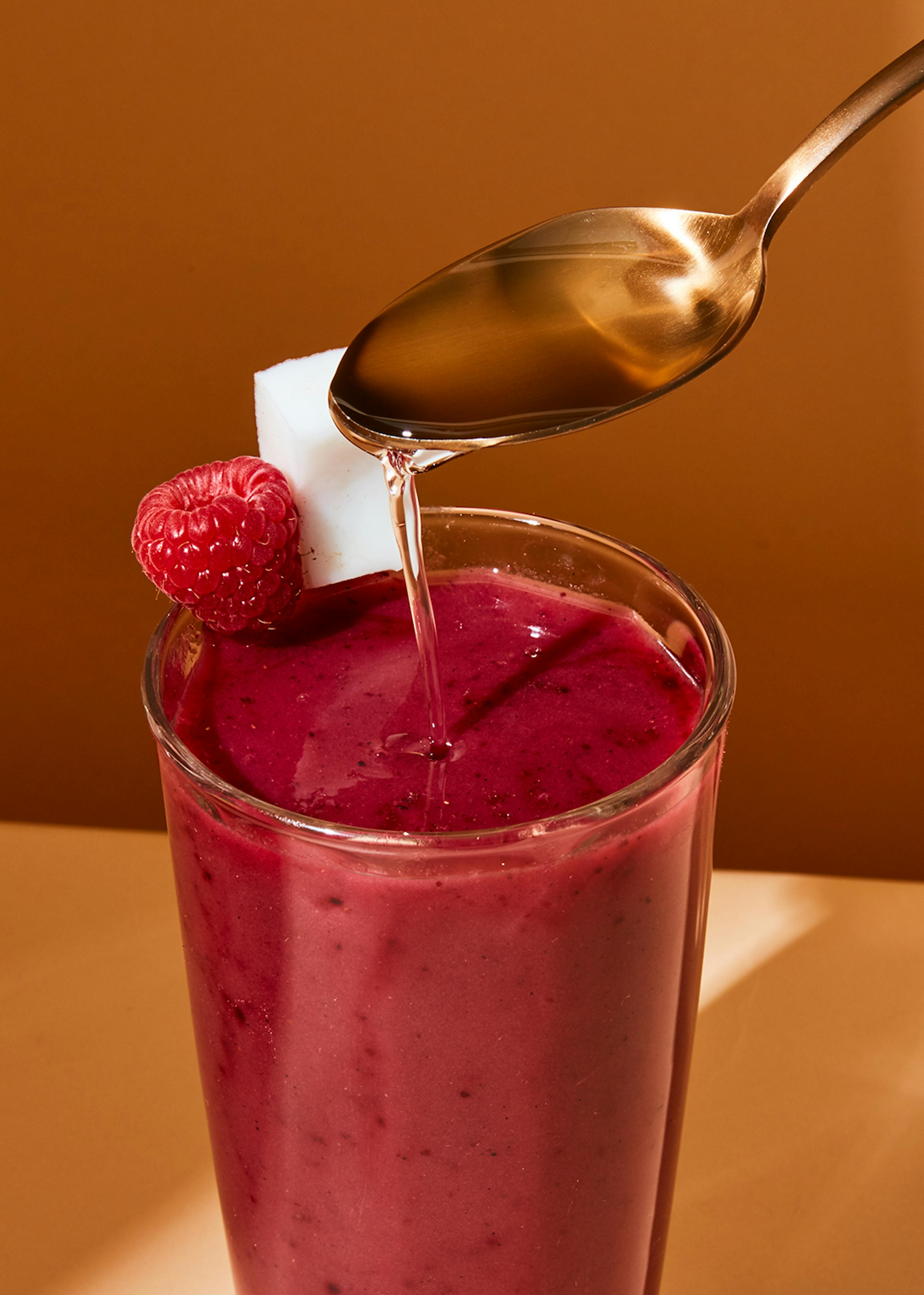 ein smoothie wird mit einem löffel in ein glas gegossen