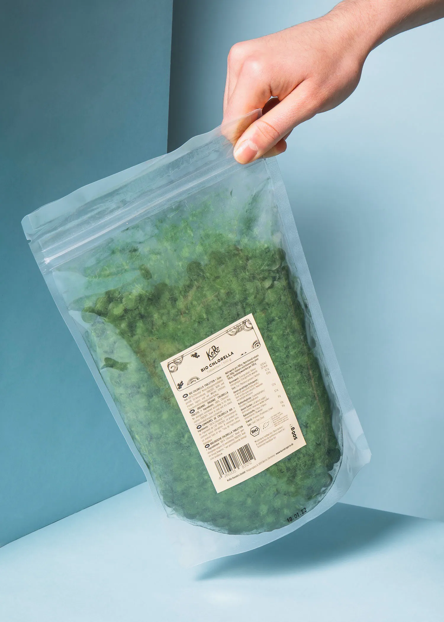 une personne tient un sac en plastique rempli de spirulina