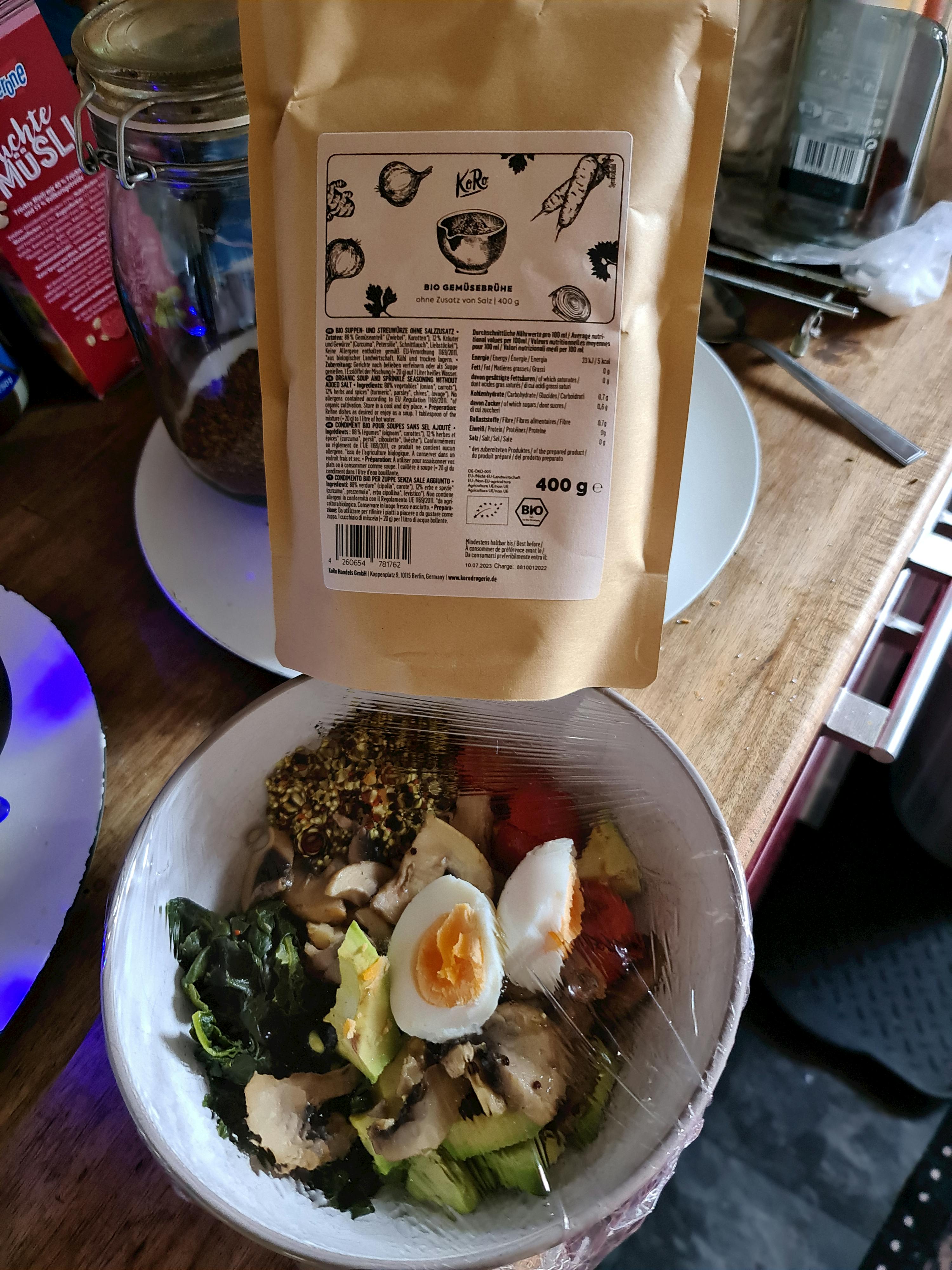 eine Schüssel mit Gemüse und Eiern neben einem braunen Plastikbeutel