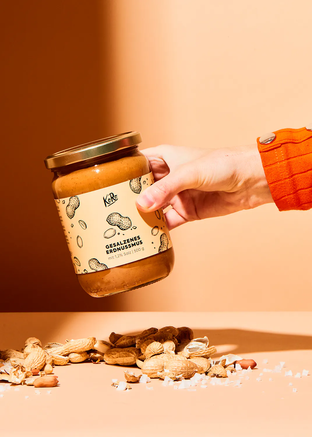 une personne tient un bocal de beurre de cacahuètes