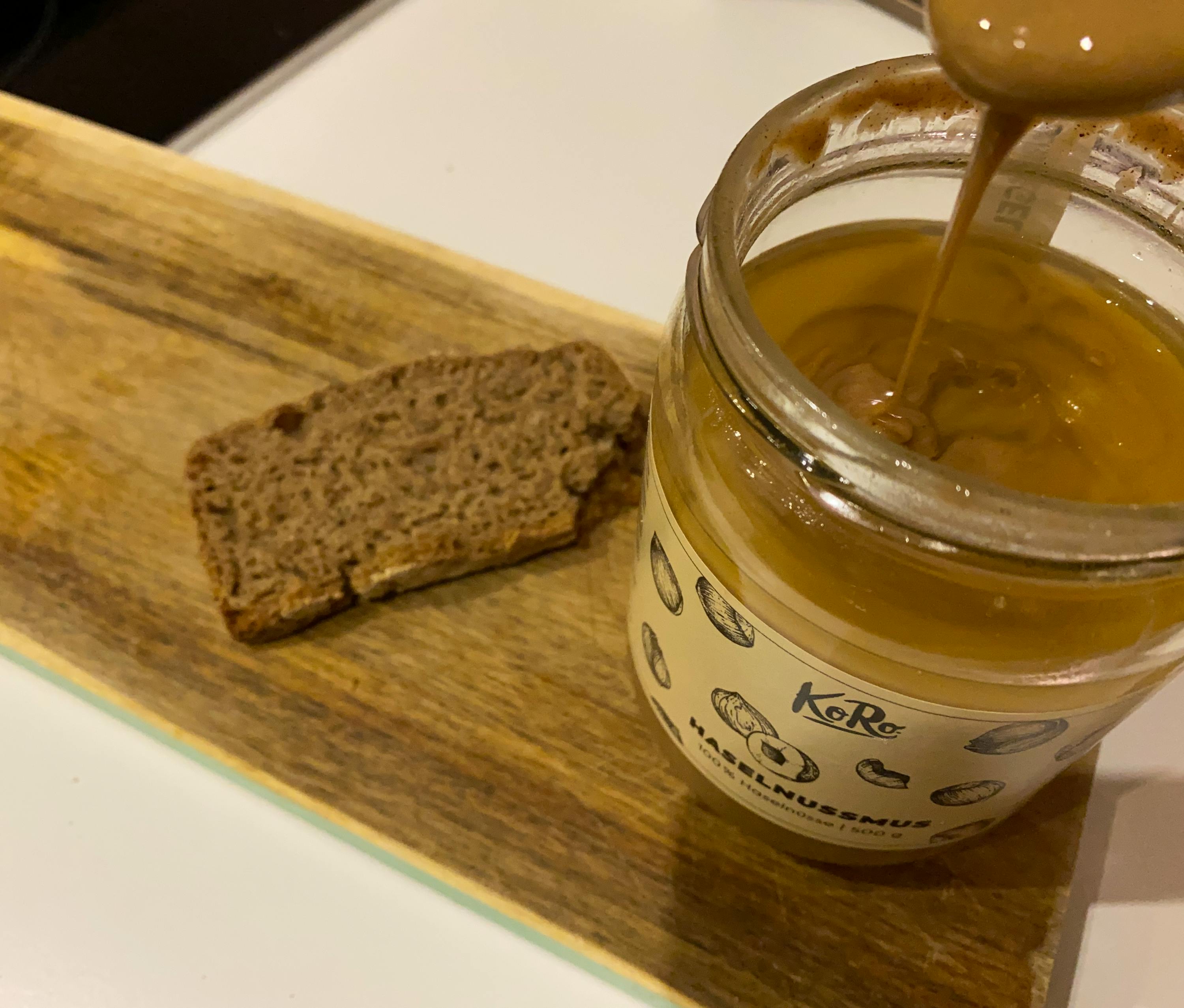 a jar of hazelnut spread next to a slice of bread