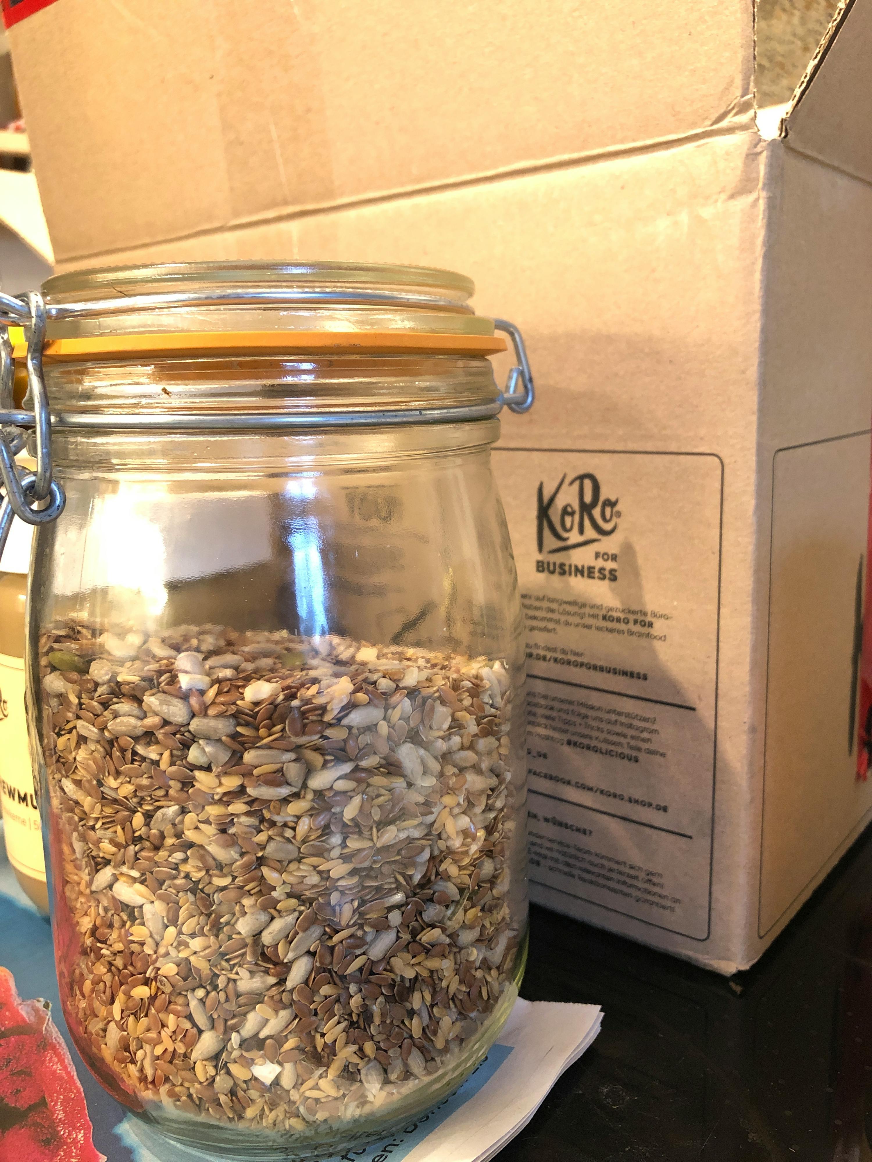 ein Glasgefäß mit Sonnenblumenkernen steht vor einer K & r-Box