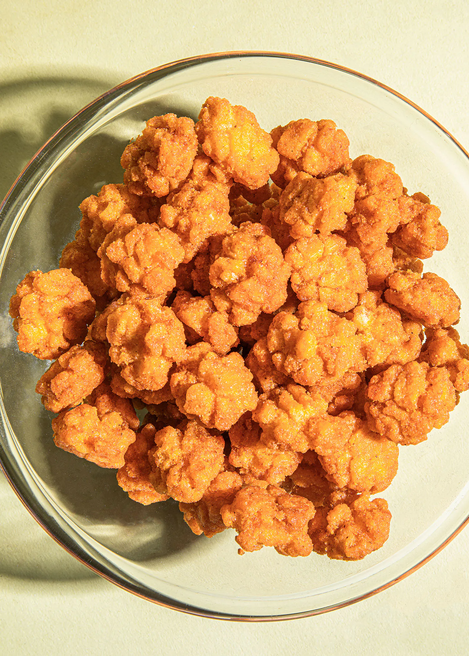 un bol en verre rempli de frites orange