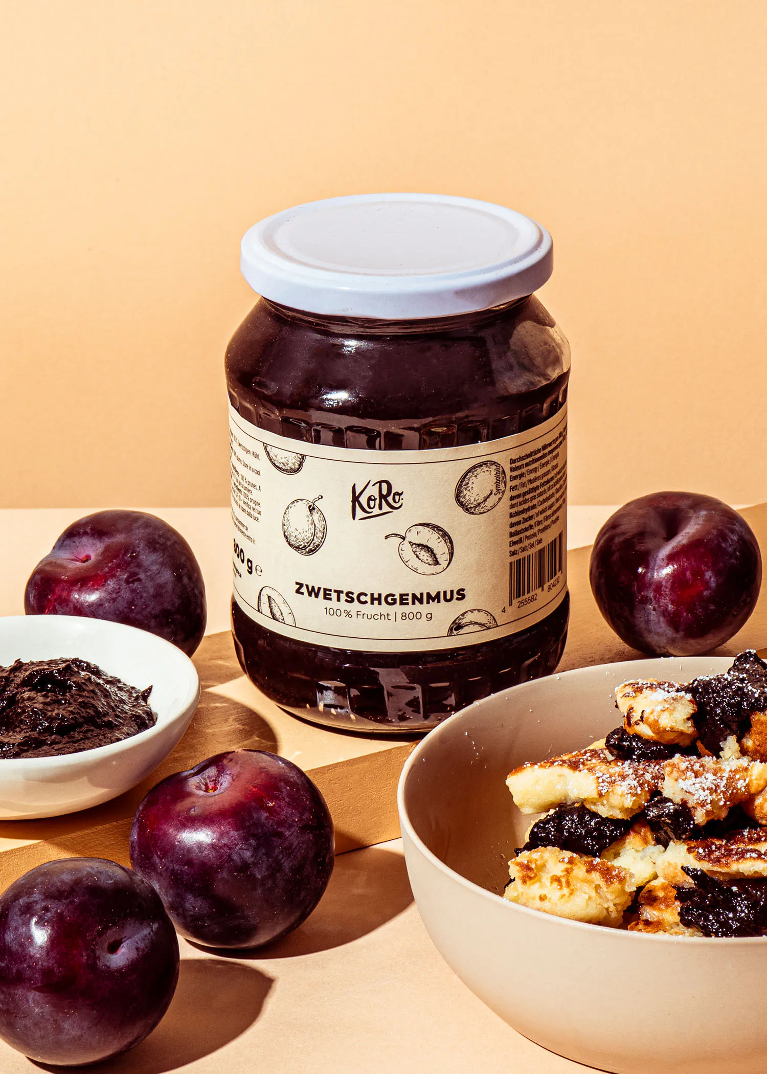 a jar of zwetschgenmus next to a bowl of food