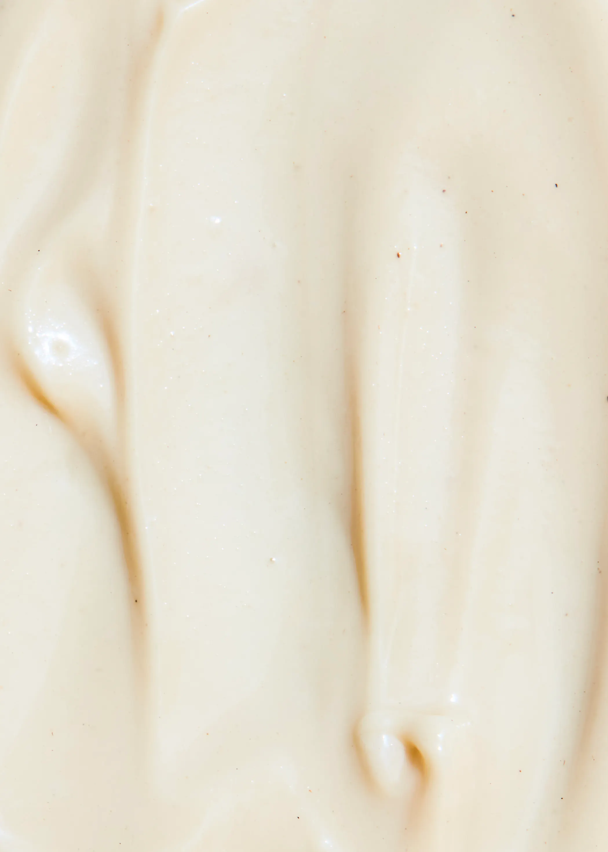 un gros plan d' une sauce blanche avec des taches rouges