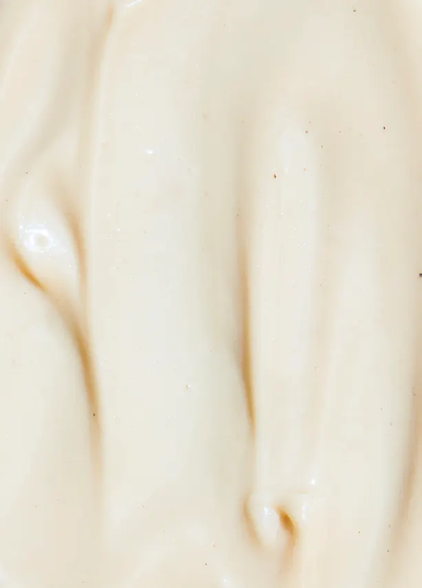 un gros plan d' une sauce blanche avec des taches rouges