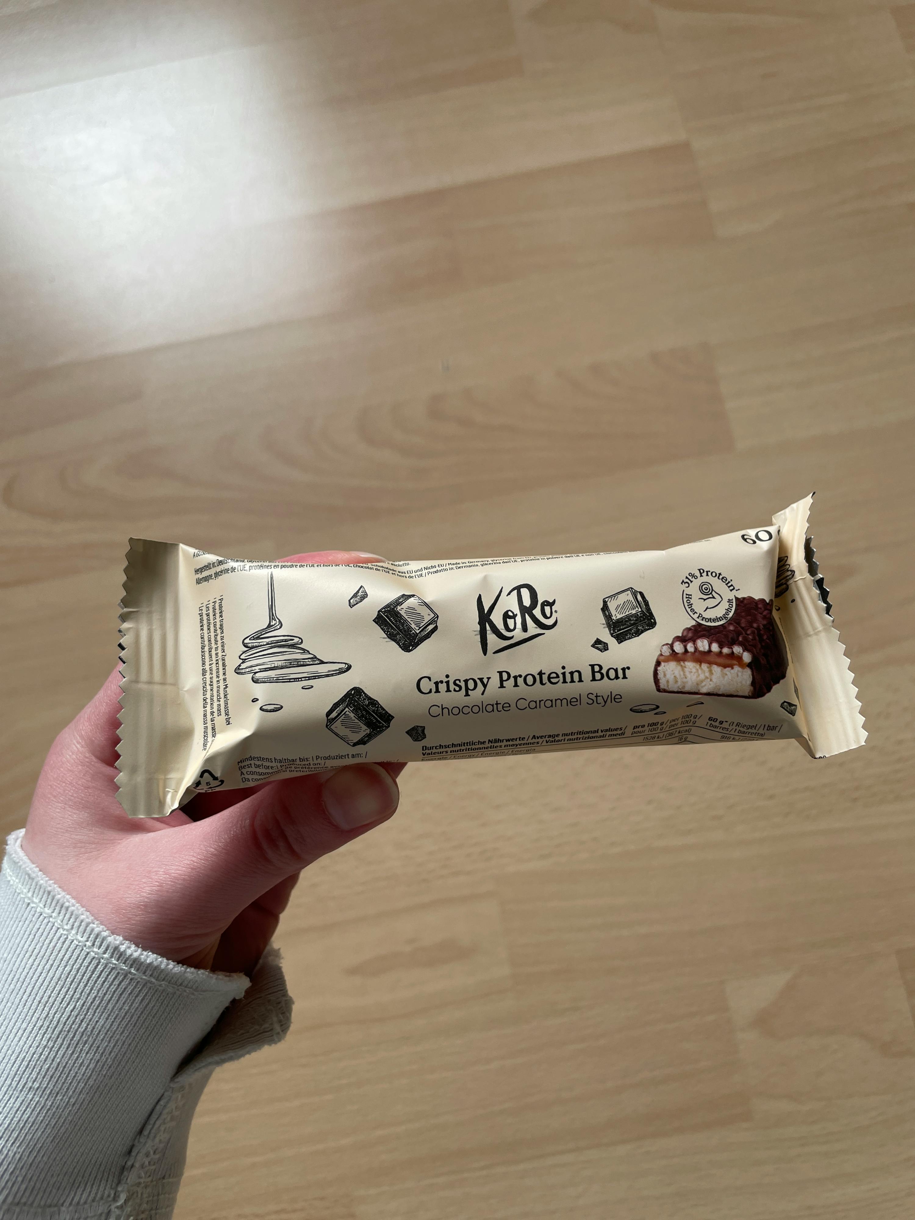 a person holding a crispy protein bar in their hand