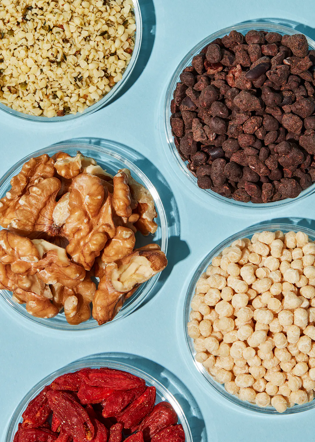 a variety of nuts and seeds on a blue surface