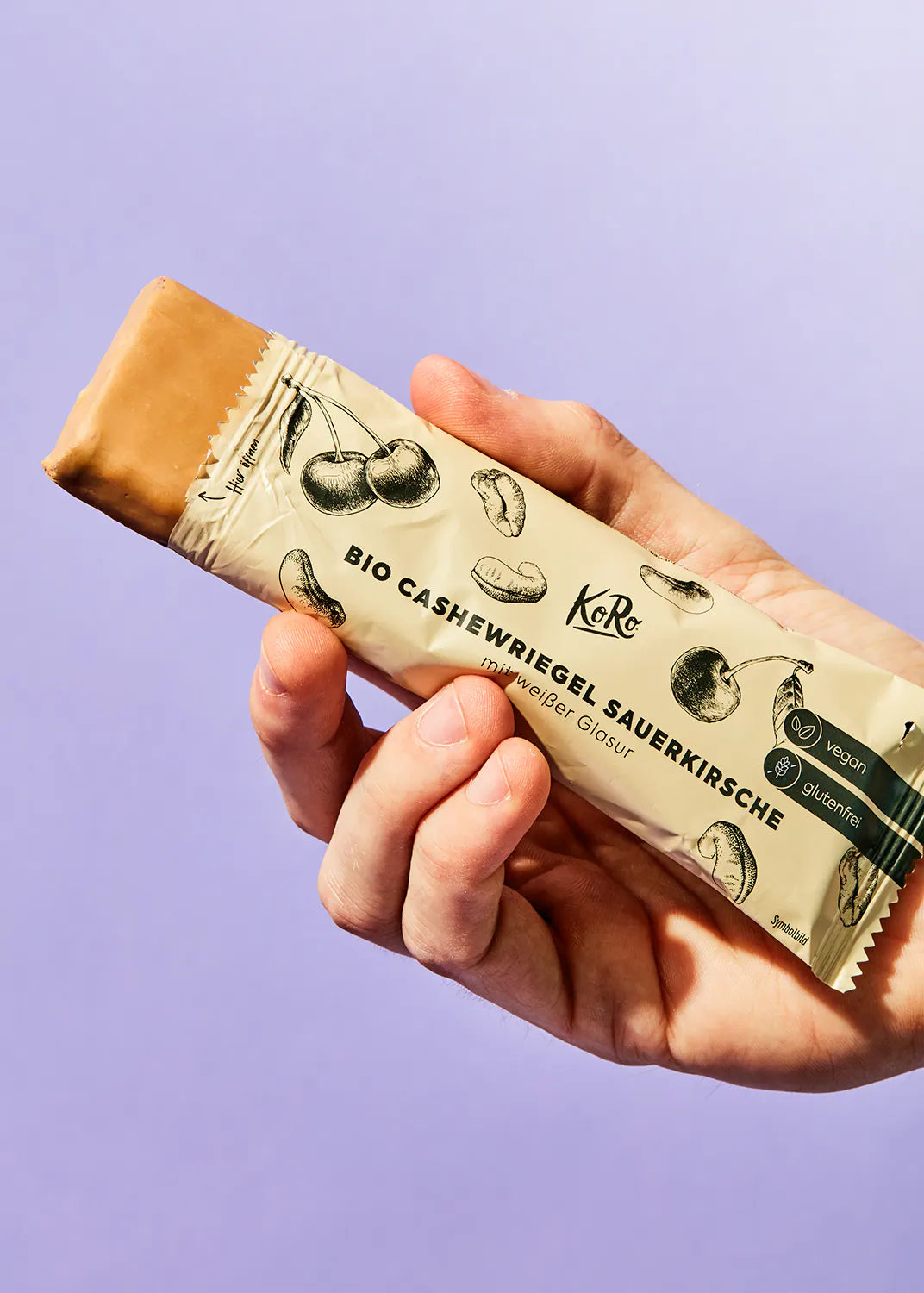 une personne tient une barre de chocolat bio avec des noix de cajou