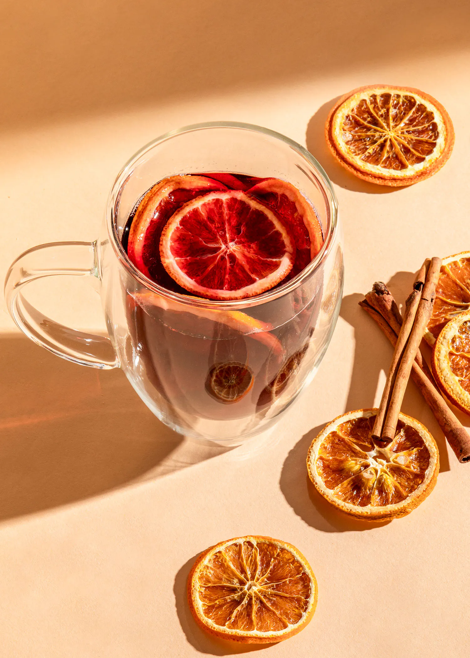 une tasse de boisson avec des tranches d' orange et des bâtons de cannelle
