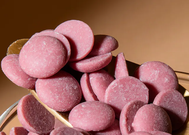 ein Haufen rosa Schokoladenscheiben in einem Glas