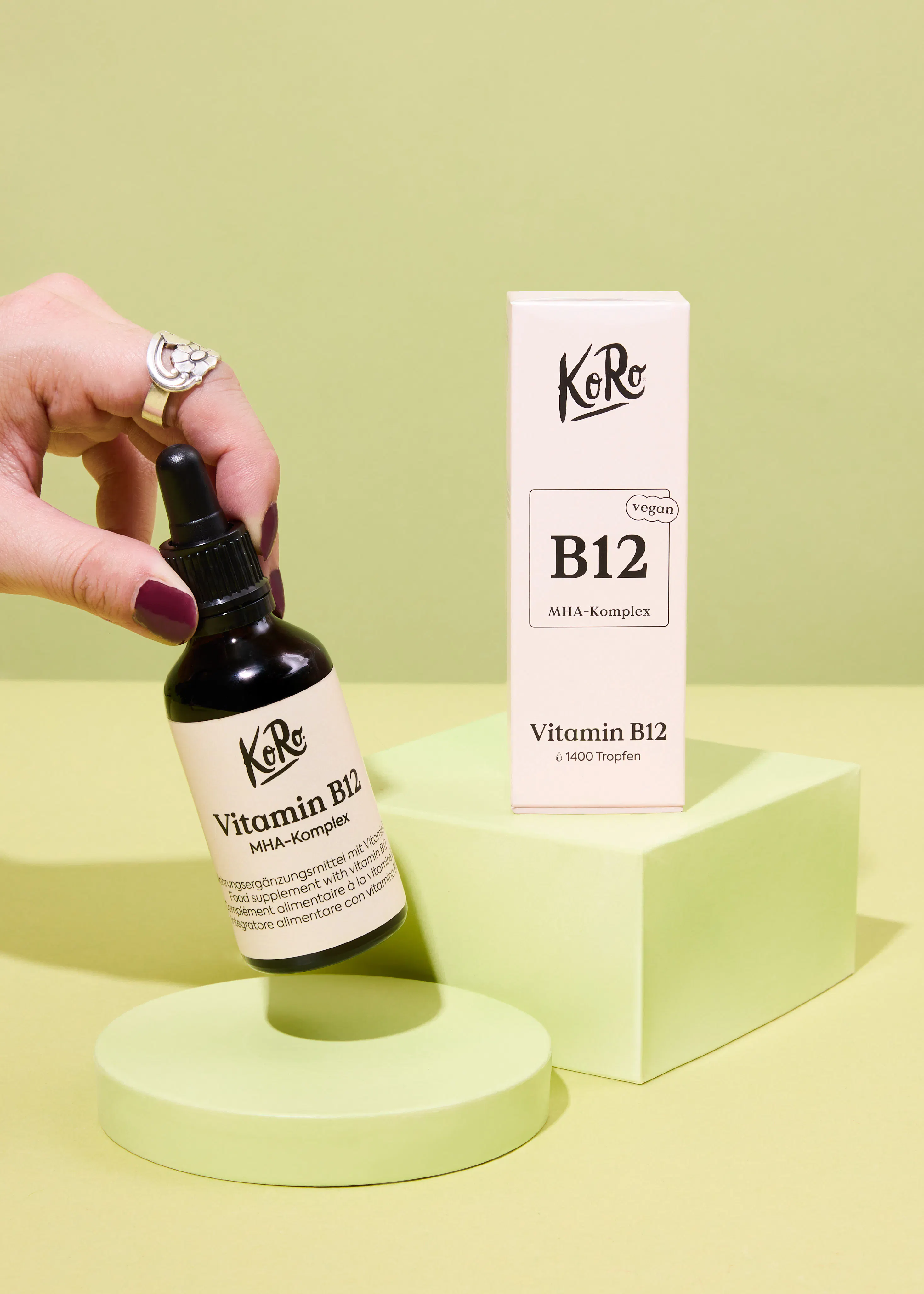 eine Person hält eine Flasche vitamin b12 in der Hand
