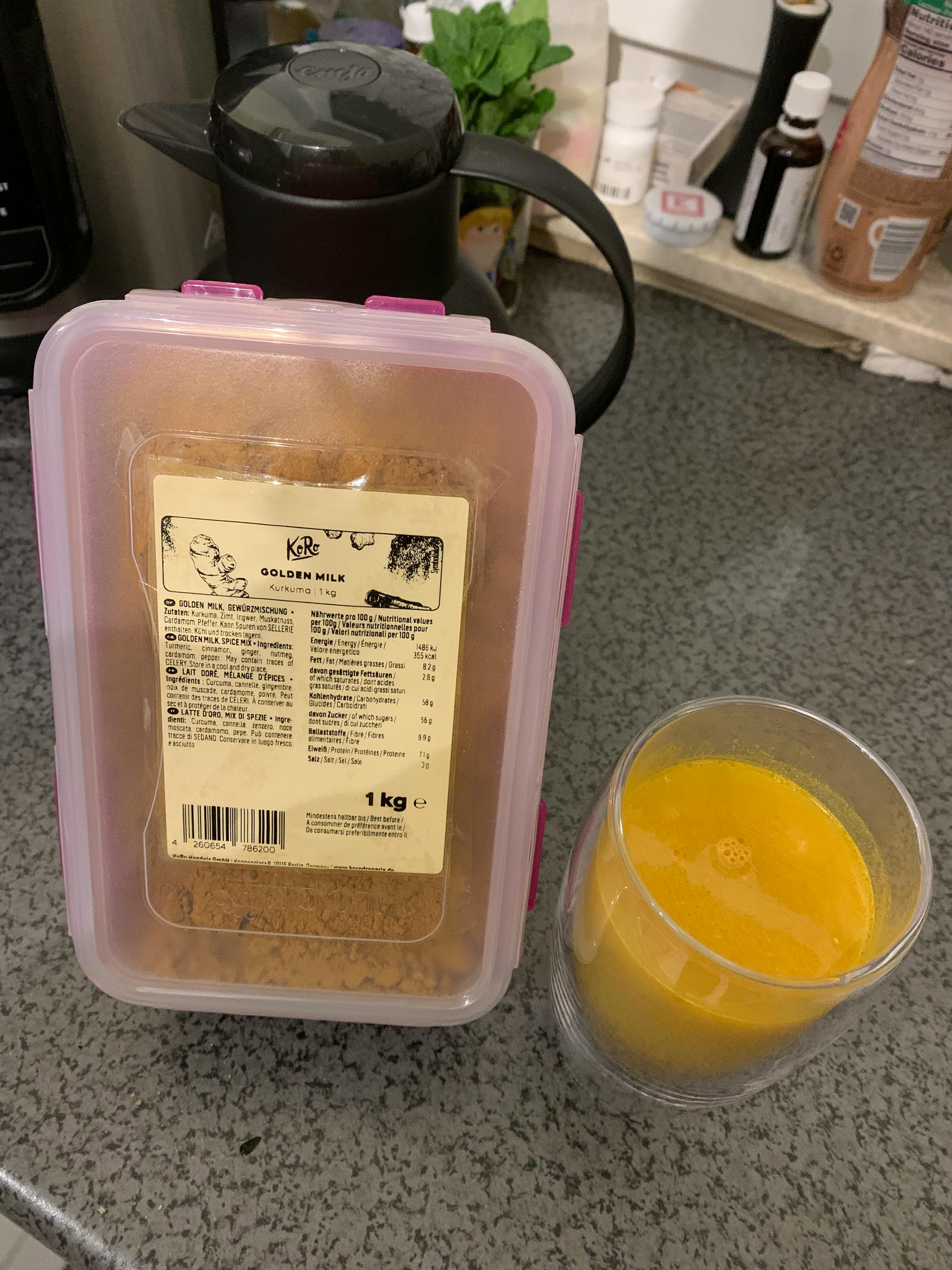 ein Plastikbehälter mit einem Etikett darauf steht neben einem Glas mit einem Smoothie