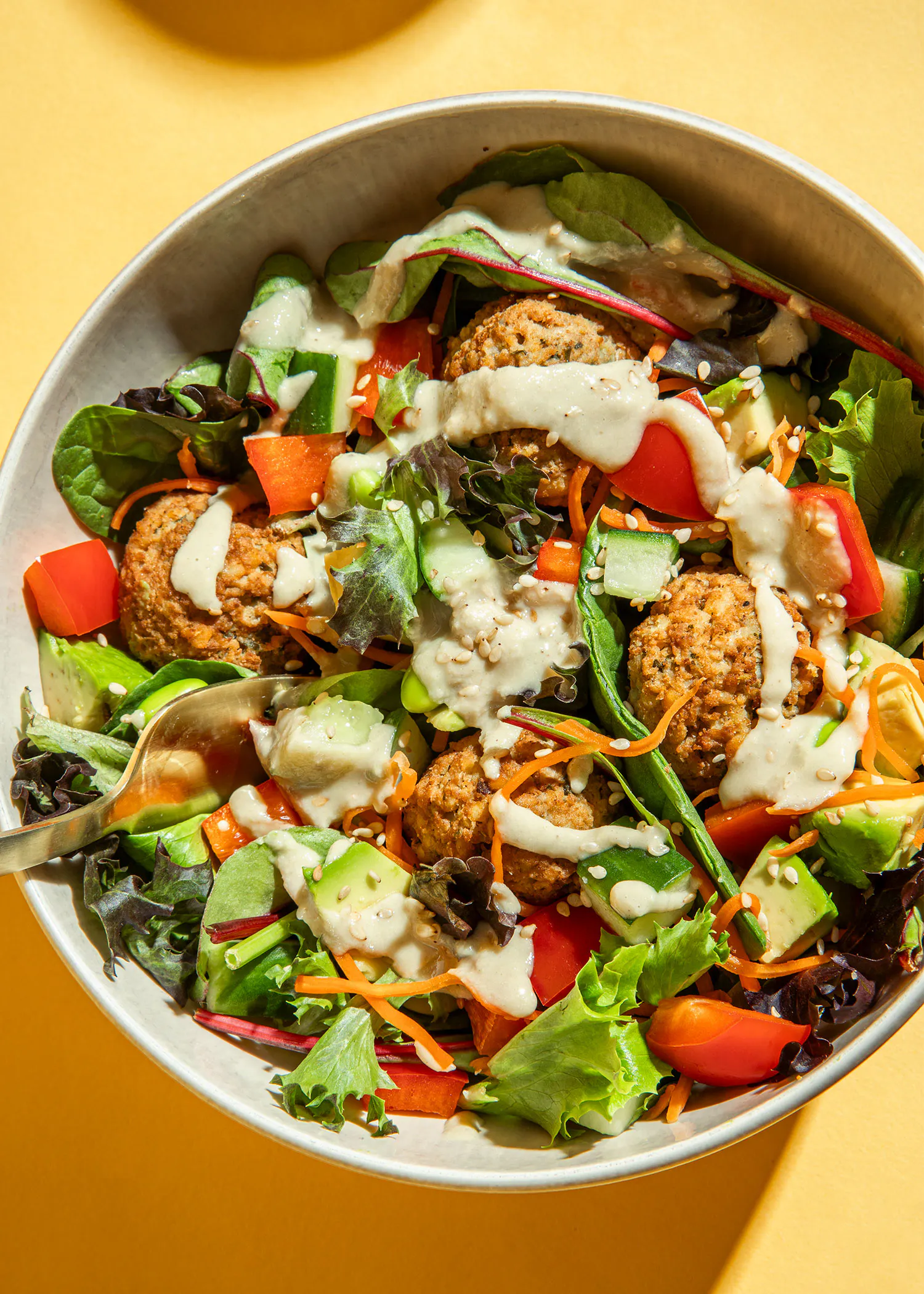 un bol de salade avec des boulettes de viande et des légumes