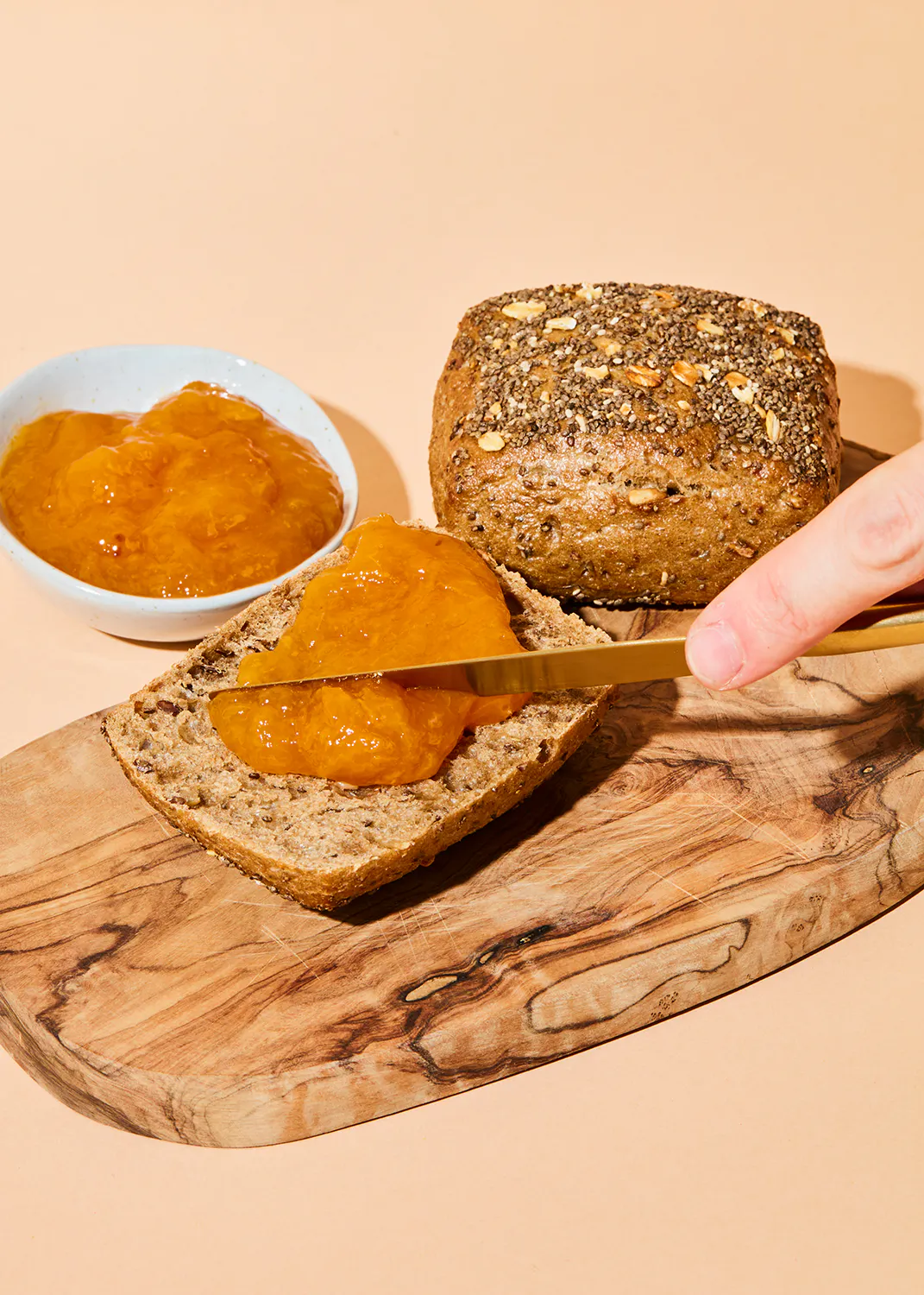 a person is spreading jam on a slice of bread