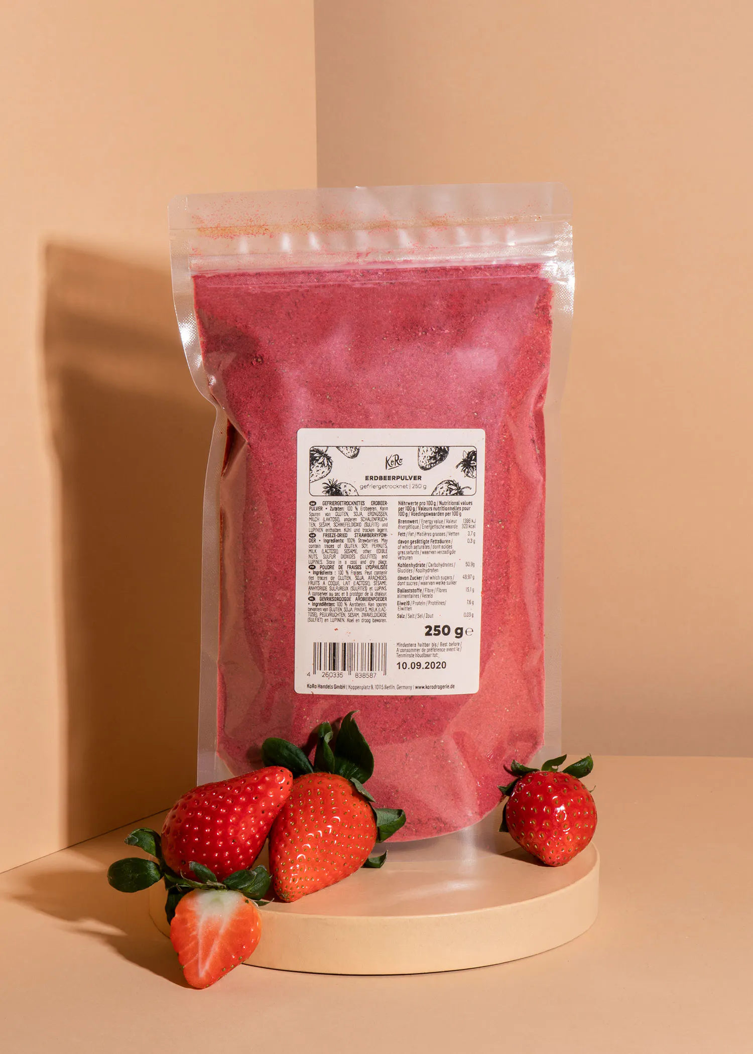un sac de poudre de fraise est posé sur une table avec des fraises