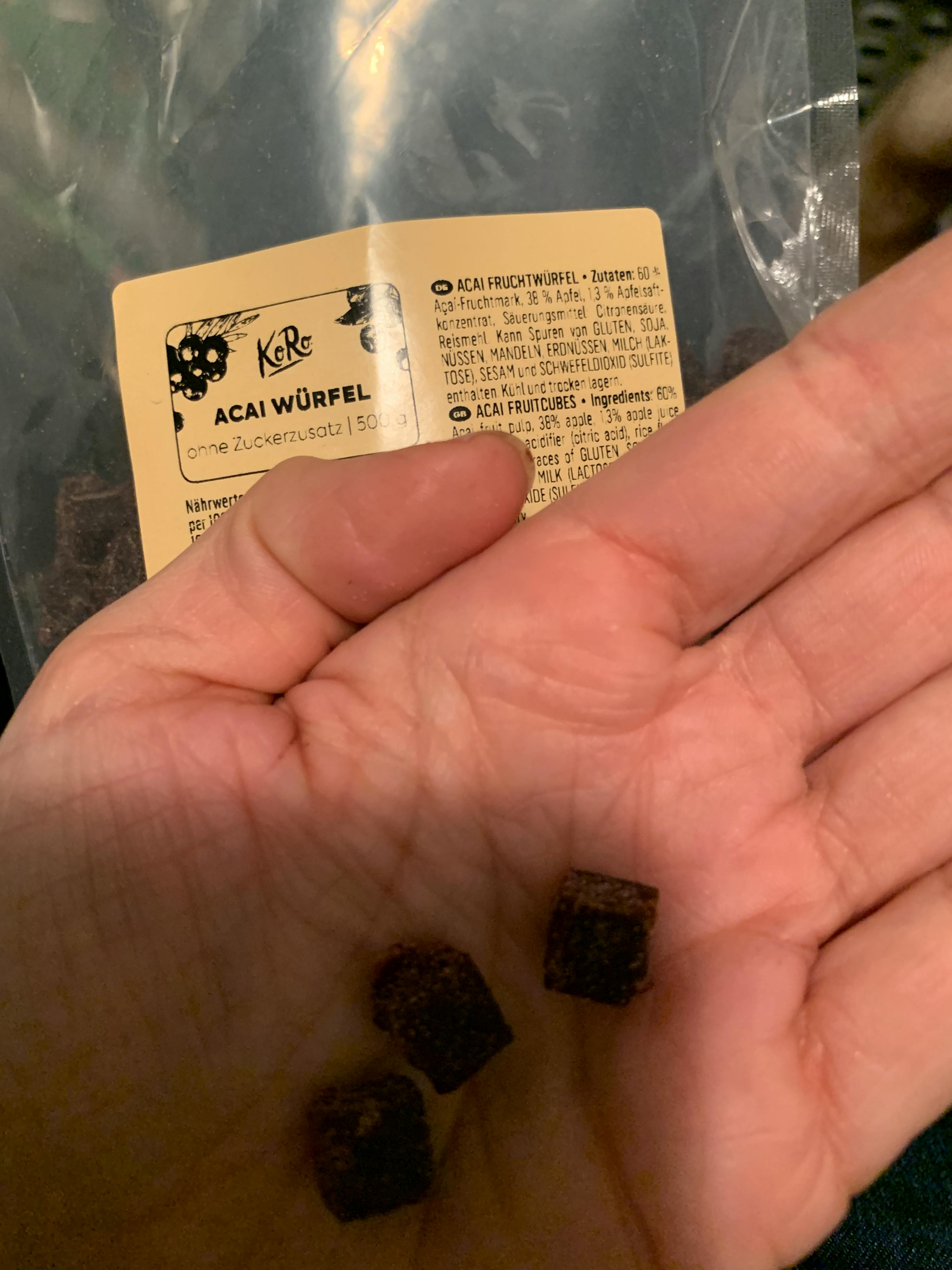 eine Person hält eine Tüte acaiwürfel in ihrer Hand