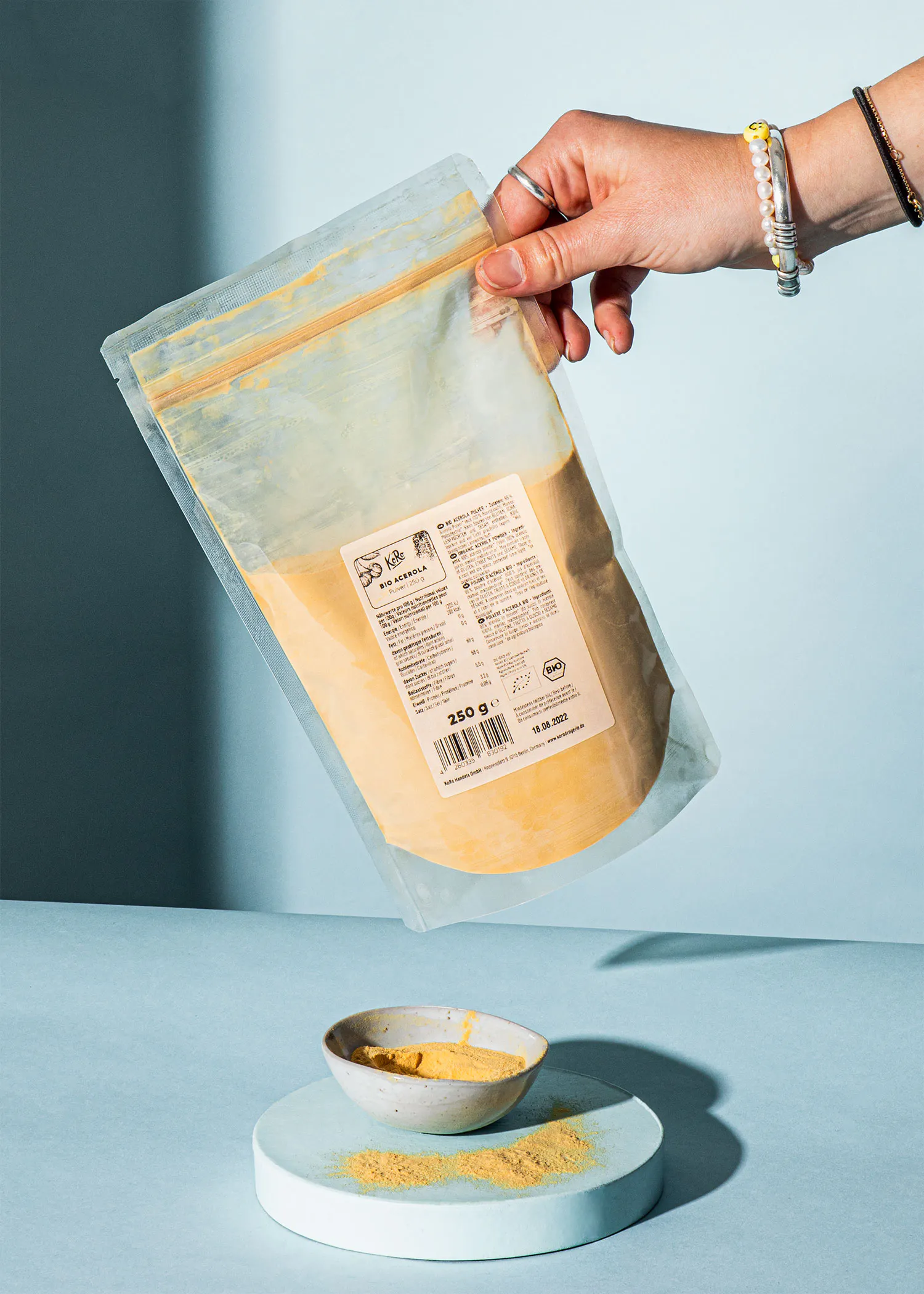 Eine Person hält einen Plastikbeutel mit 250 g Essen in der Hand