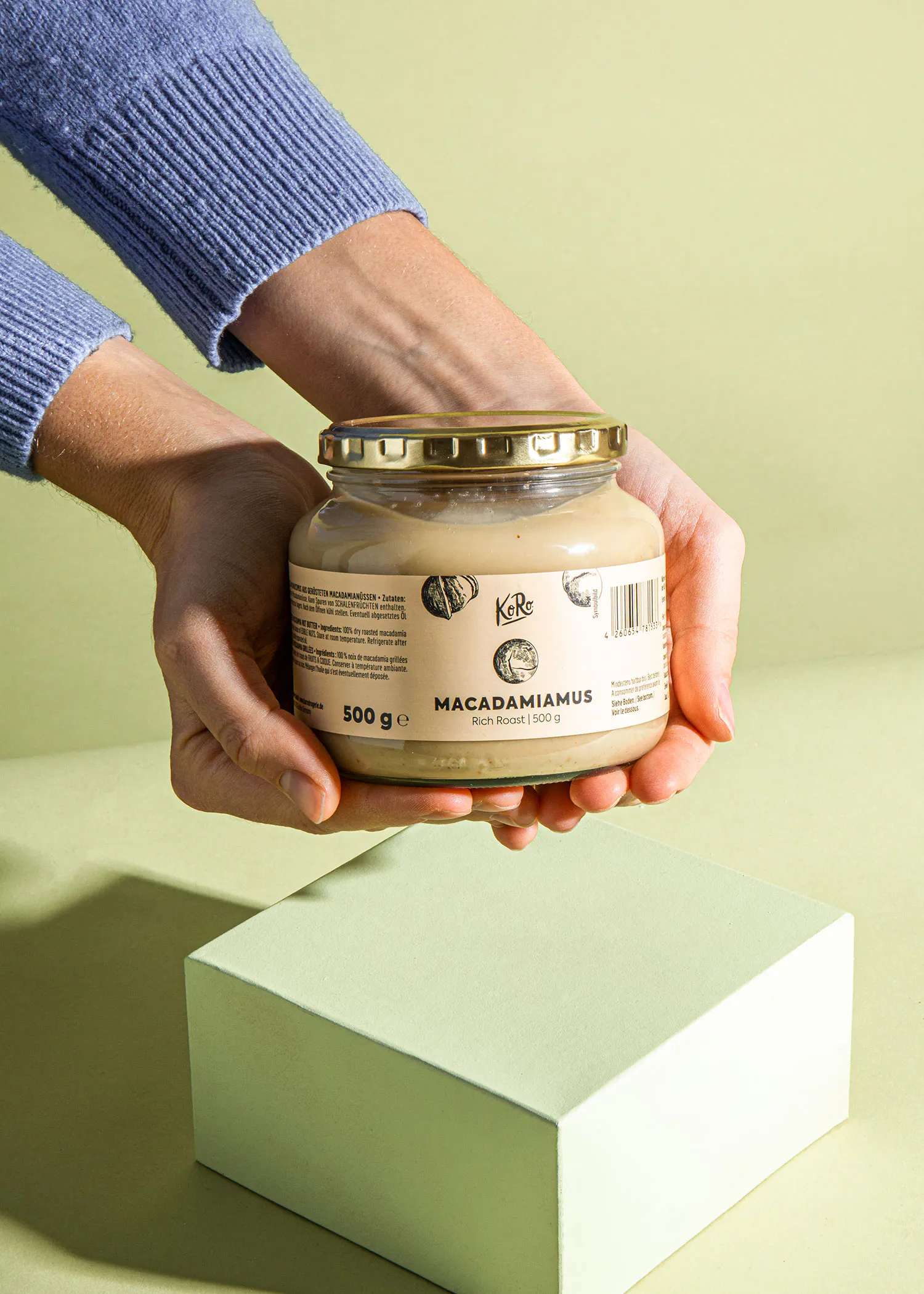 eine Person hält ein Glas macadamiamus in den Händen