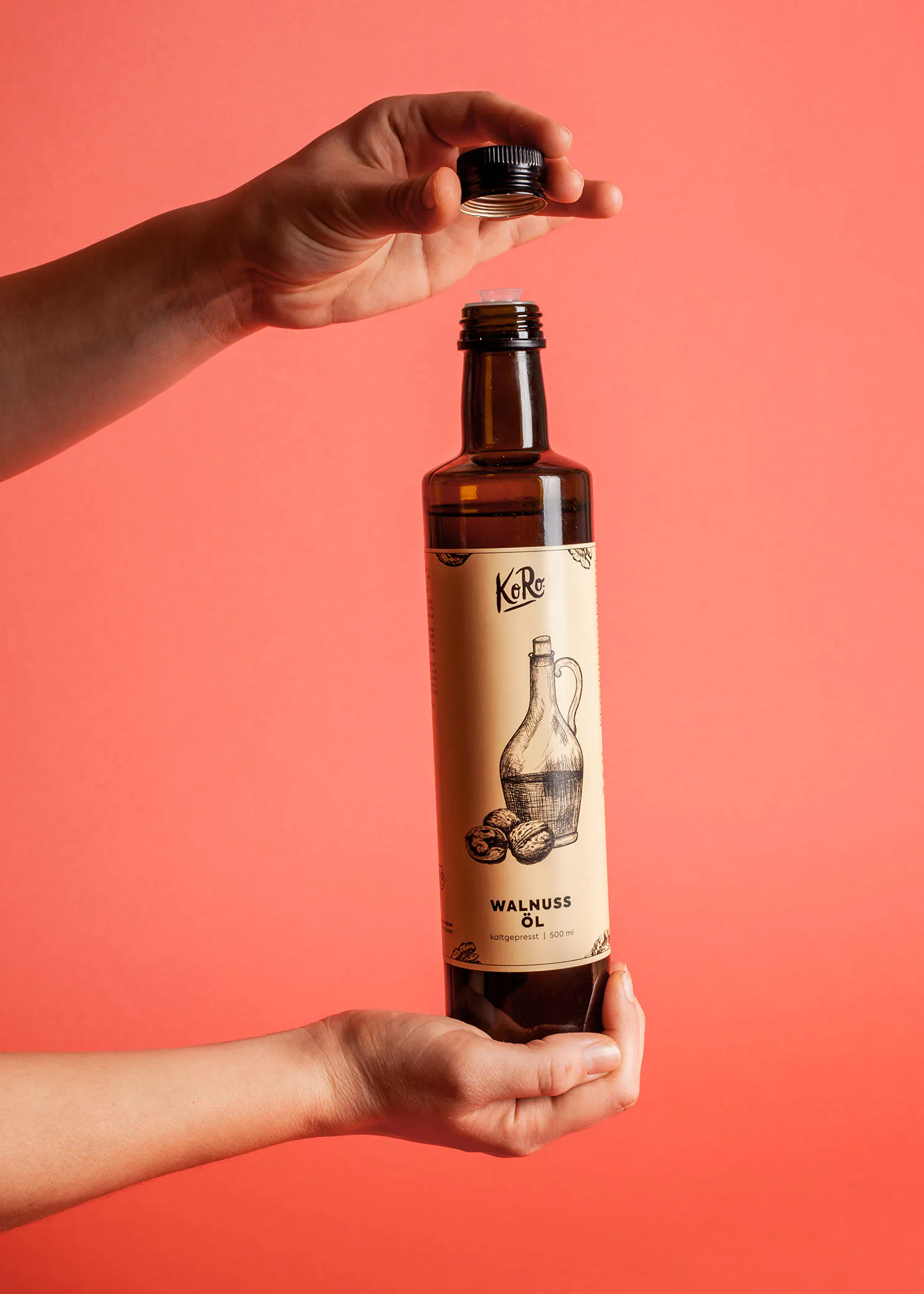 Eine Person hält eine Flasche Walnussöl in der Hand