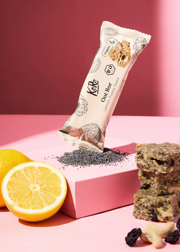 une barre d' avoine avec des graines de pavot est posée sur une table rose