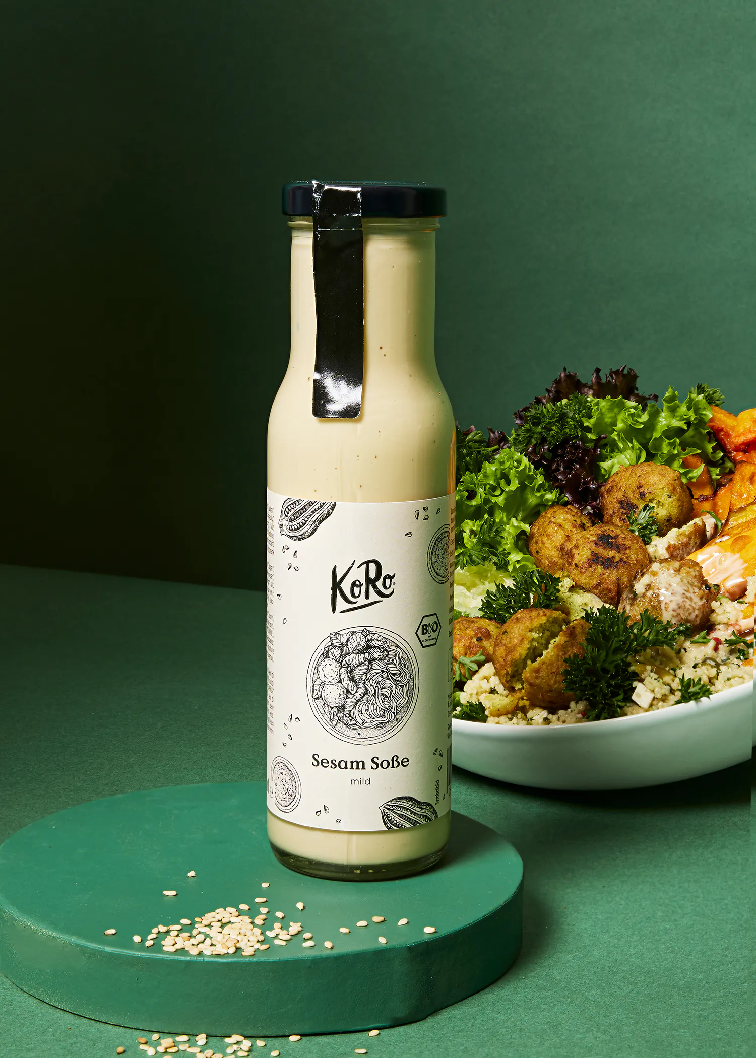 eine Flasche Sesam-Soße steht neben einem Salat