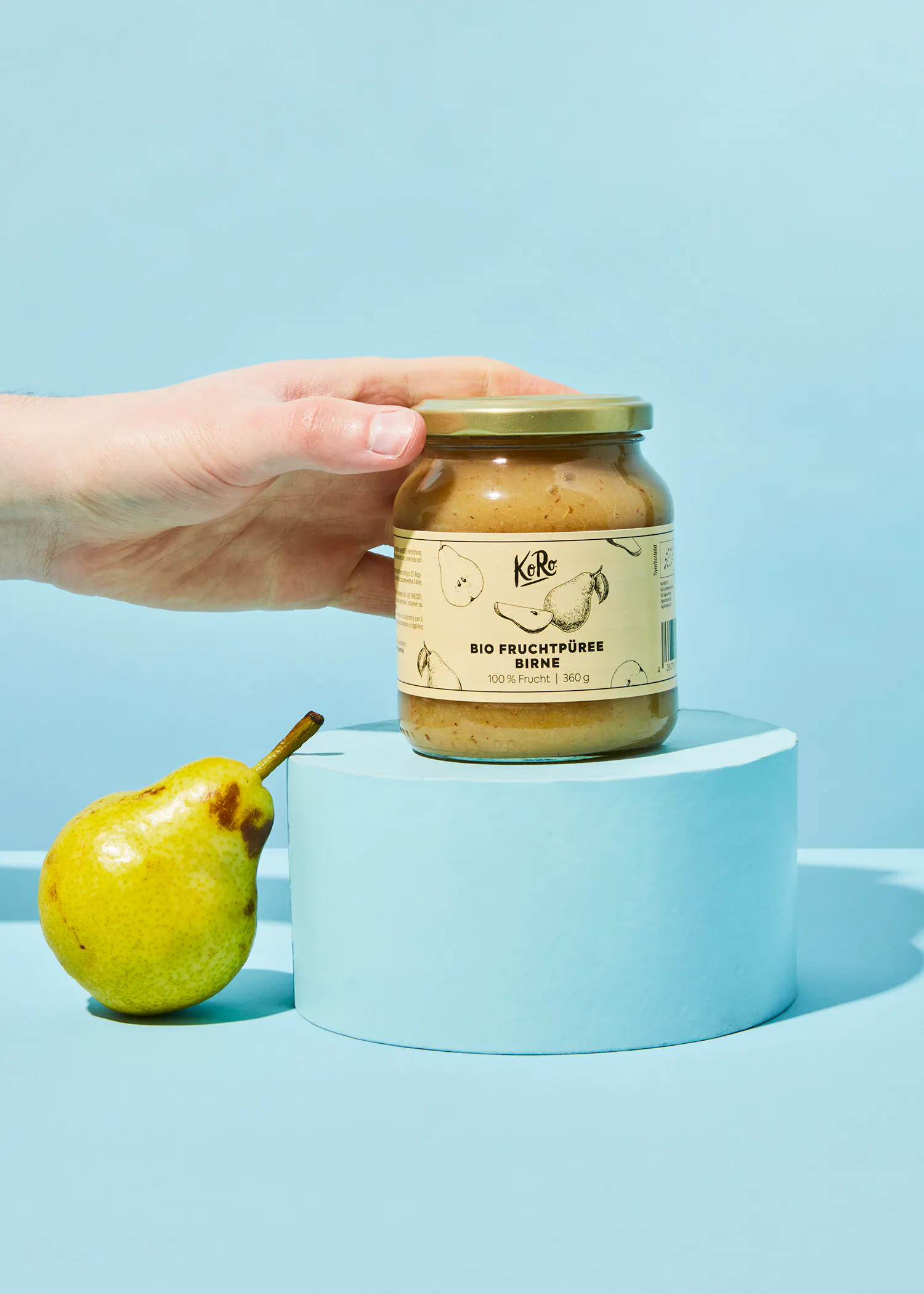 a person is holding a jar of fruchtpuree birne