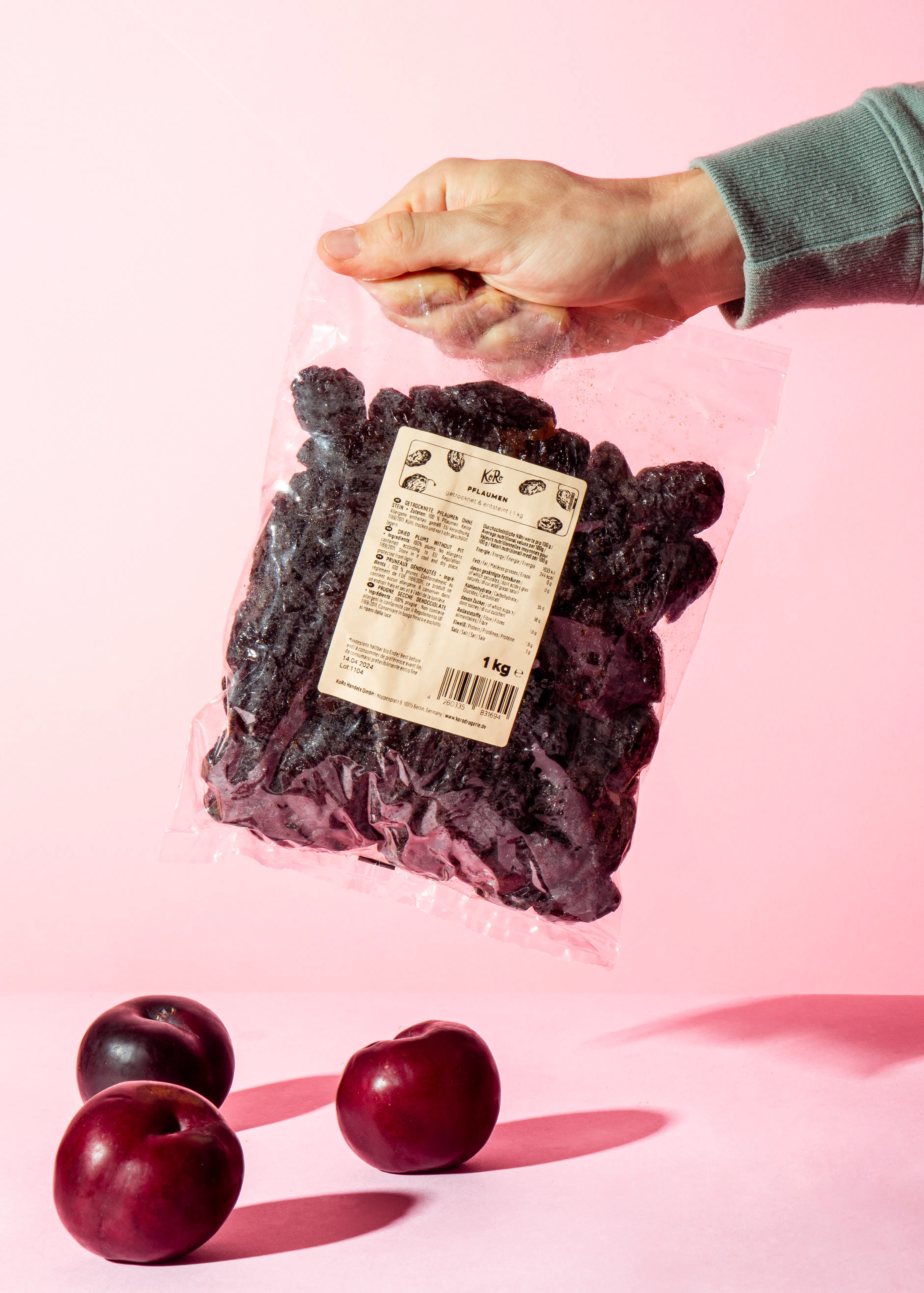 une personne tient un sac de prunes séchées de 1 kg